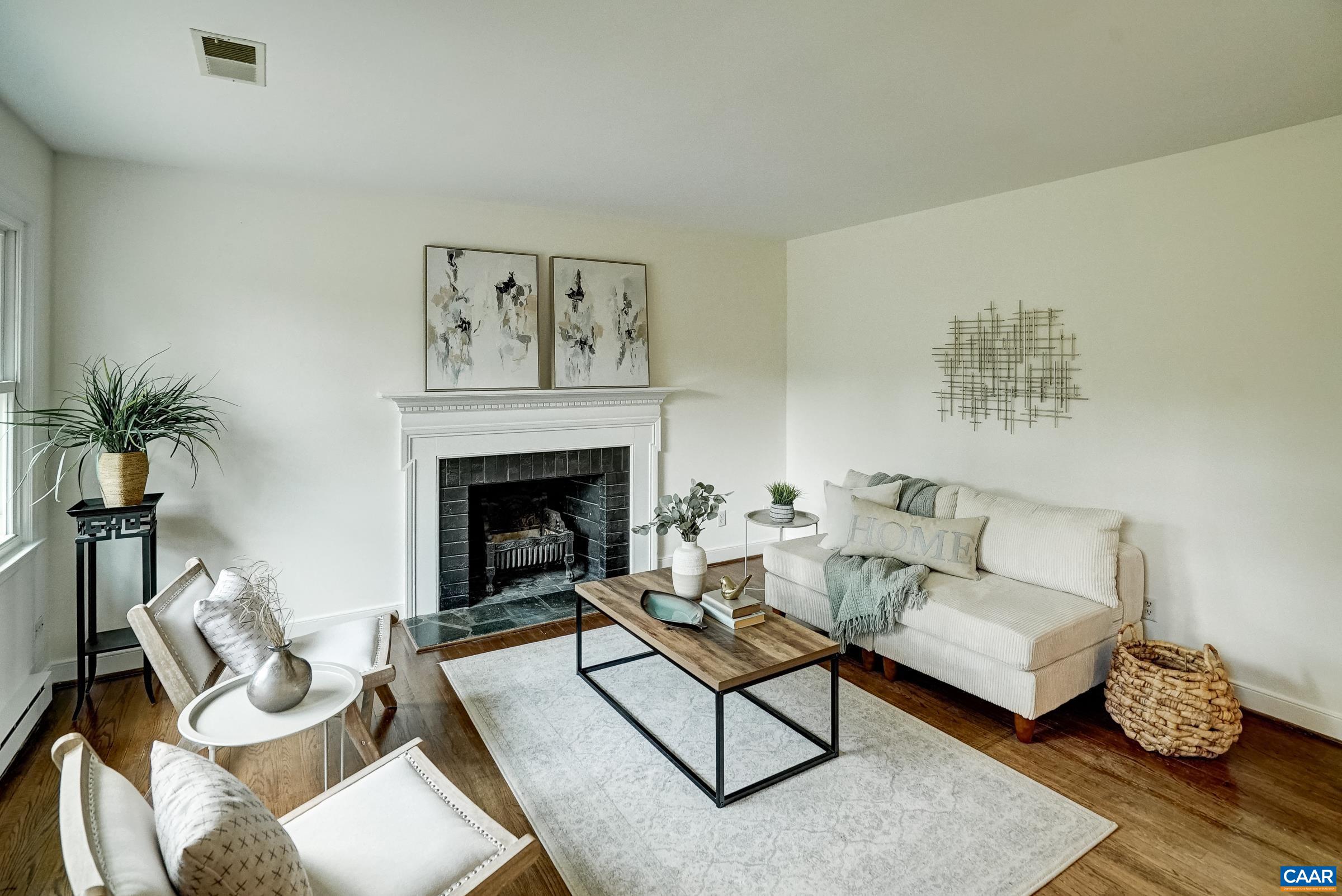 Light filled living room features wood-burning fireplace. Light filled living room features wood-burning fireplace.