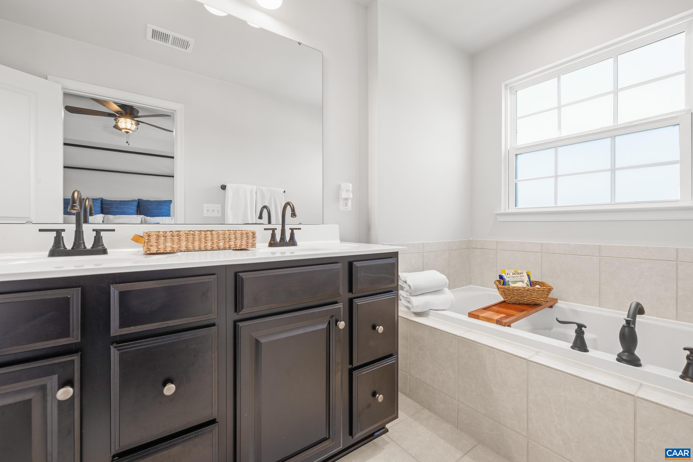 Dual vanities with soaking tub in the primary suite Dual vanities with soaking tub in the primary suite