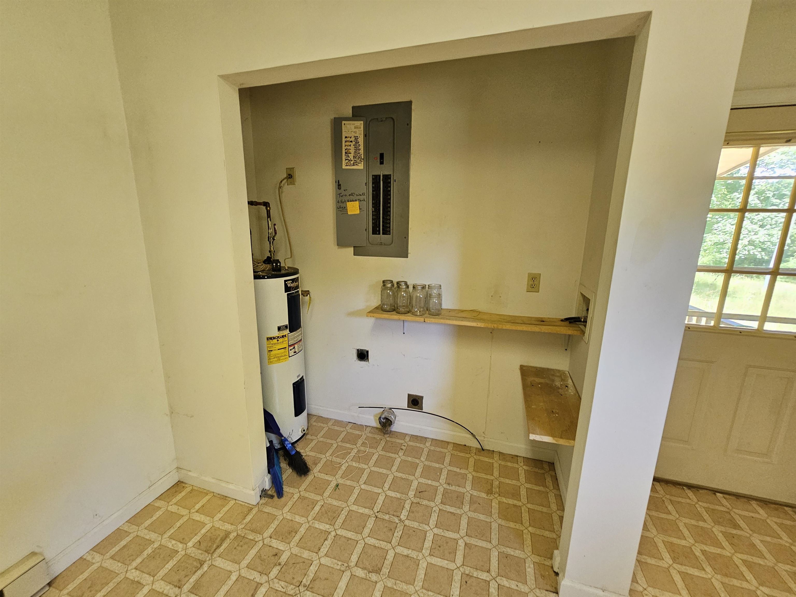 Laundry closet with water heater and panel box.
