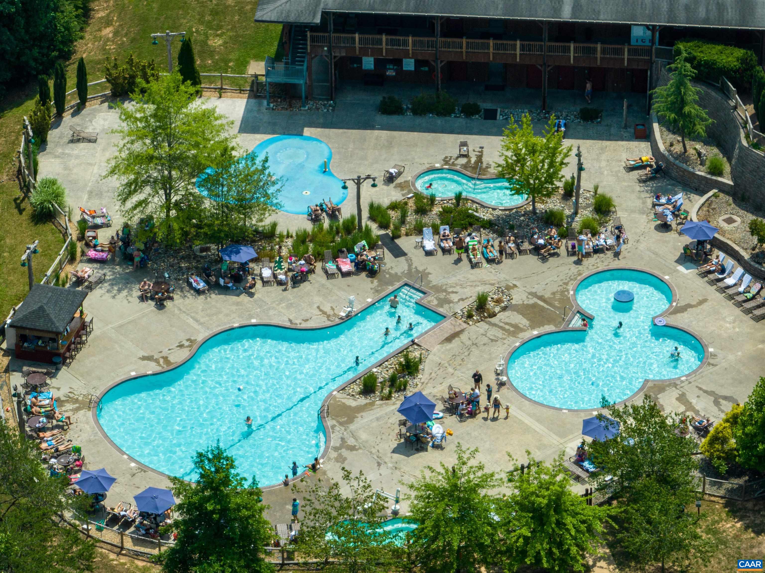 The expansive main recreation area by the General Store generally features three distinct water sections: a main swimming pool, a designated activity/kiddie pool, and an interactive splash pad for children.