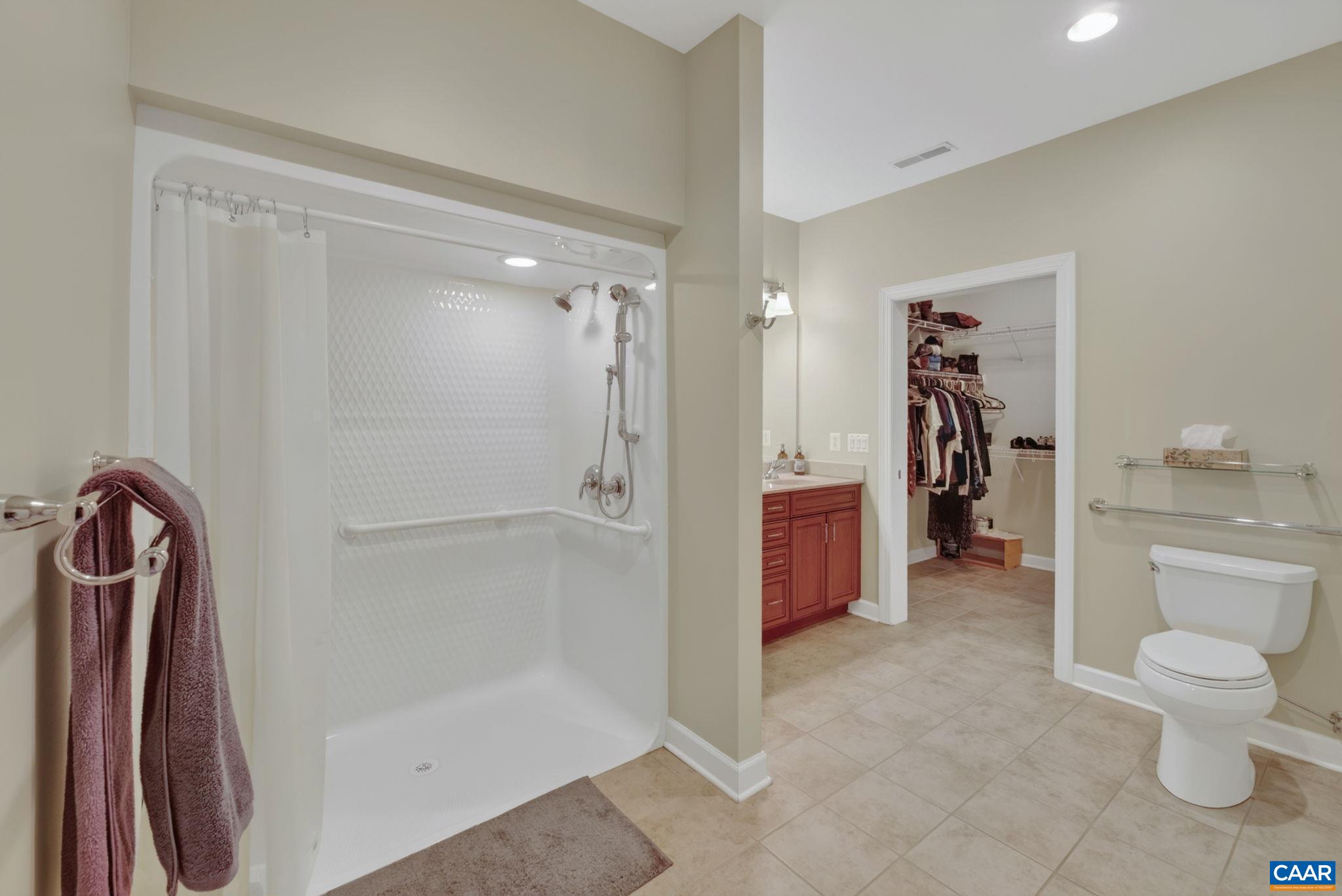 Tiled primary bath with zero-entry shower.