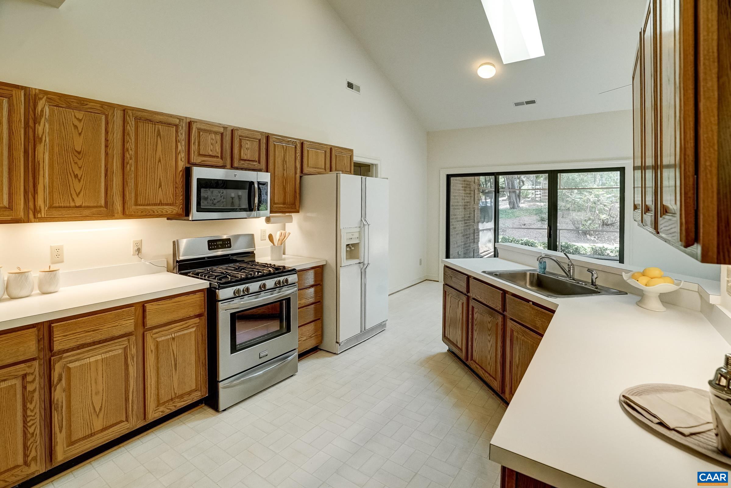 Practical kitchen features solid wood cabinets, updated gas range and dishwasher.