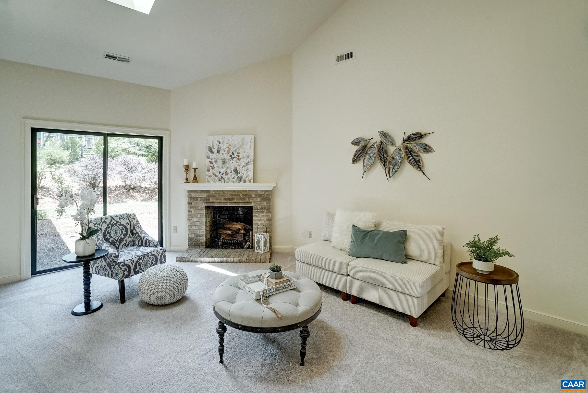 Vaulted great room with skylights and brick wood-burning fireplace.