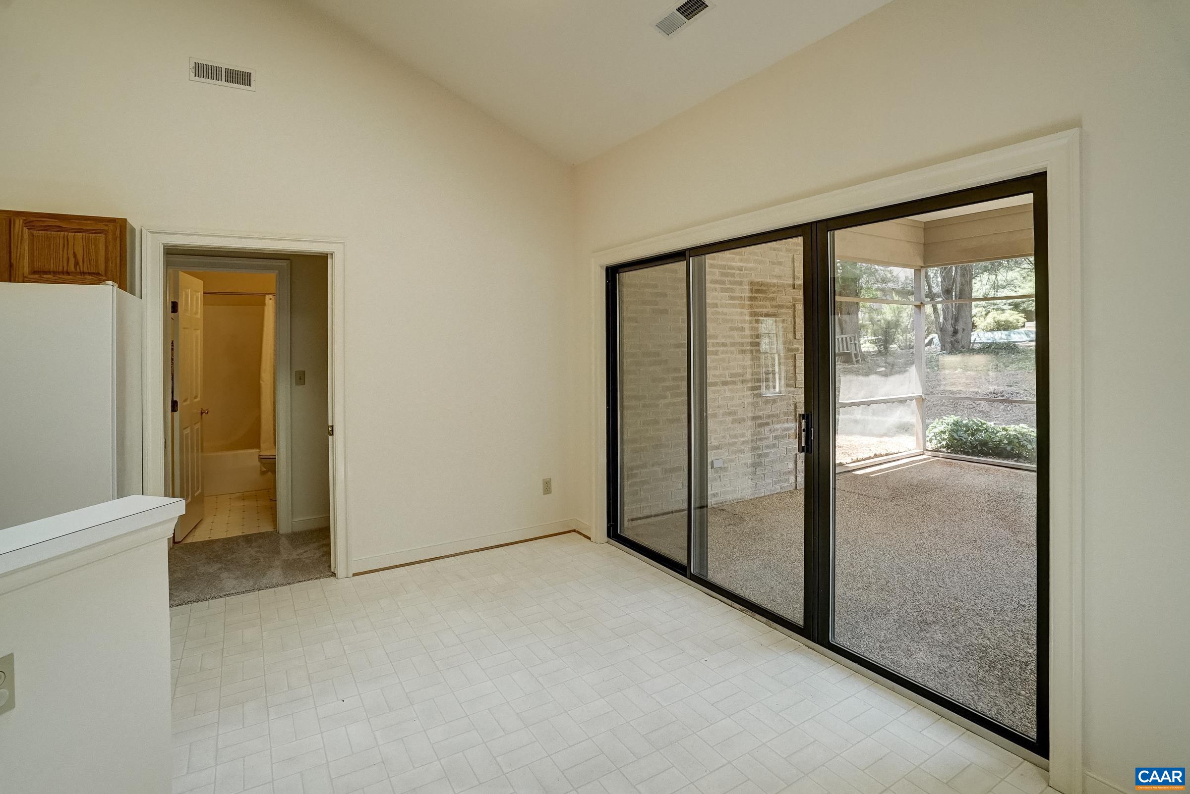 Eat-in breakfast nook with sliding doors leading to screened porch.