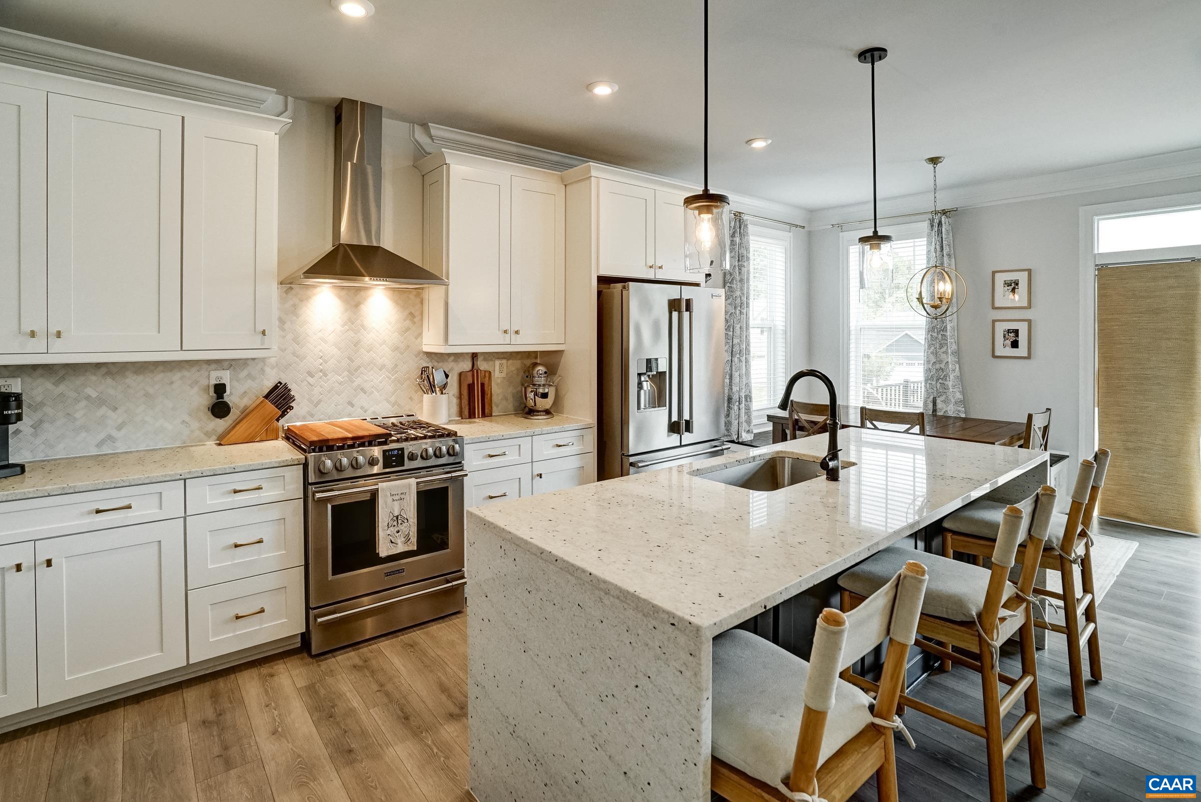 Stainless appliances and herringbone backsplash in this high end kitchen.