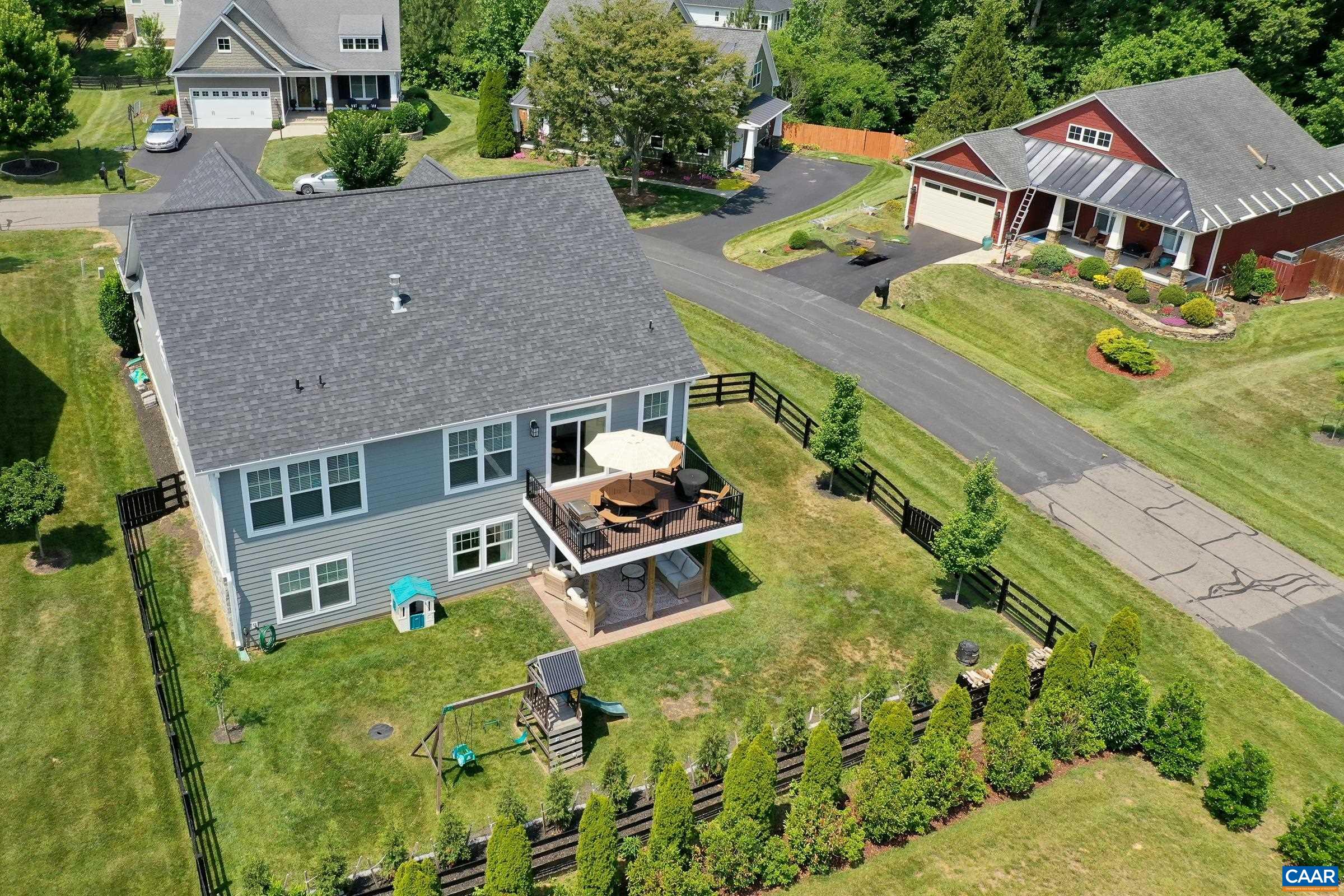 Flat fenced yard with arbor vitae hedge and playset!