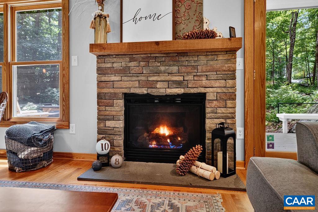 The stone fireplace with gas logs is a standout feature of the great room, bringing both character and comfort to the space.
