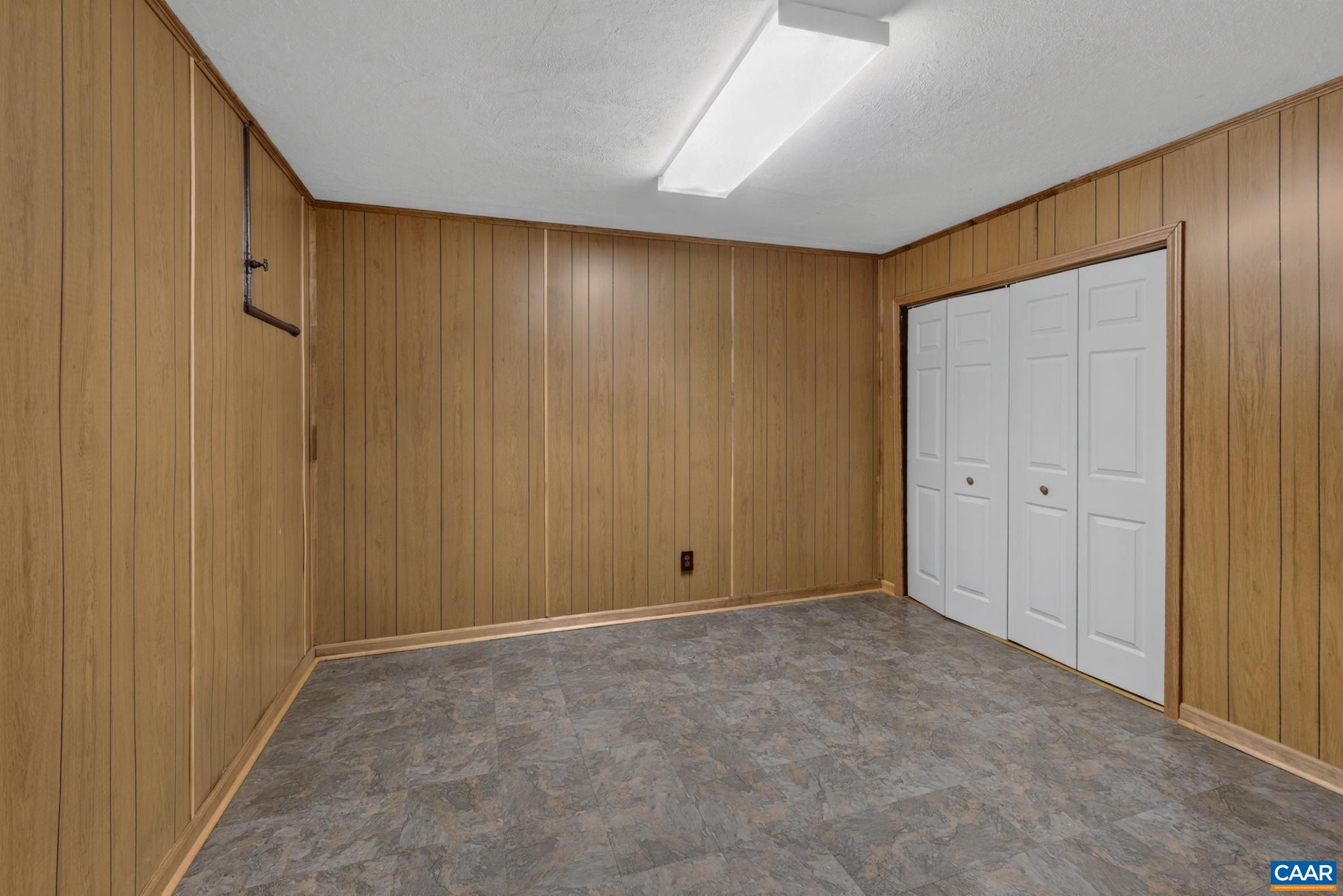 This flex space in the basement is ideal for a workout, hobby, office, or storage area.