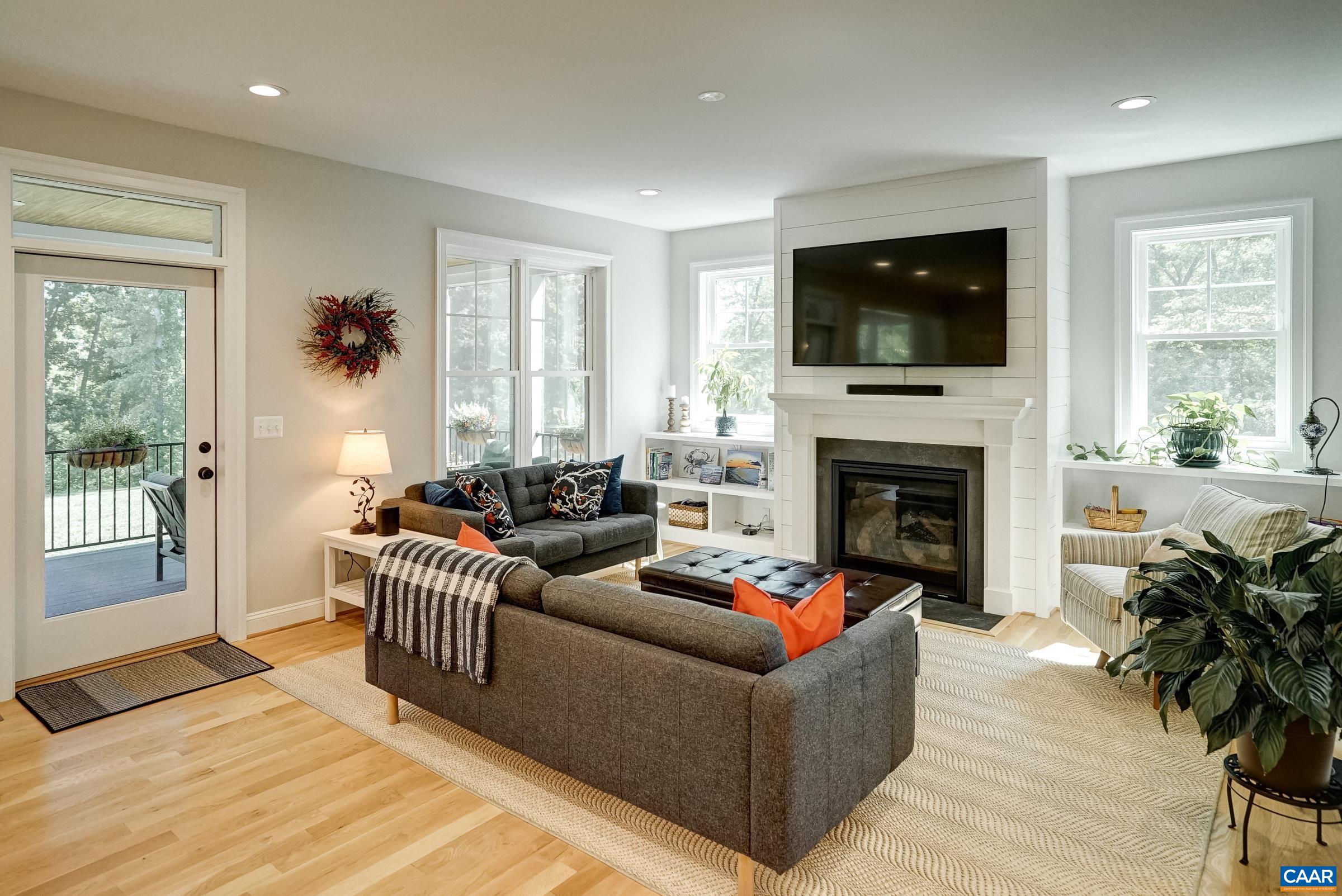 Great room features gas fireplace flanked by built in storage.