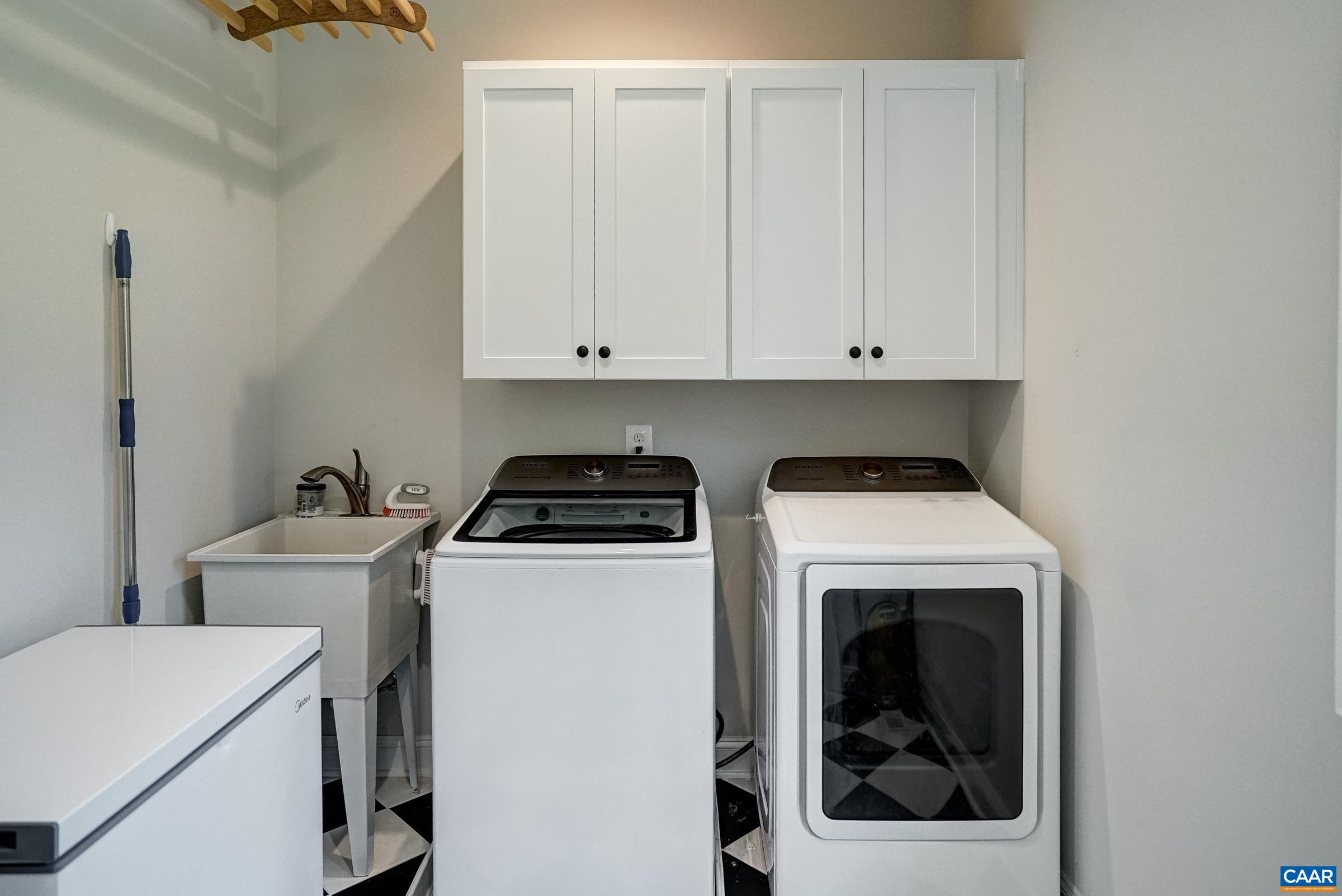 Main level laundry room features washer and dryer and extra storage.