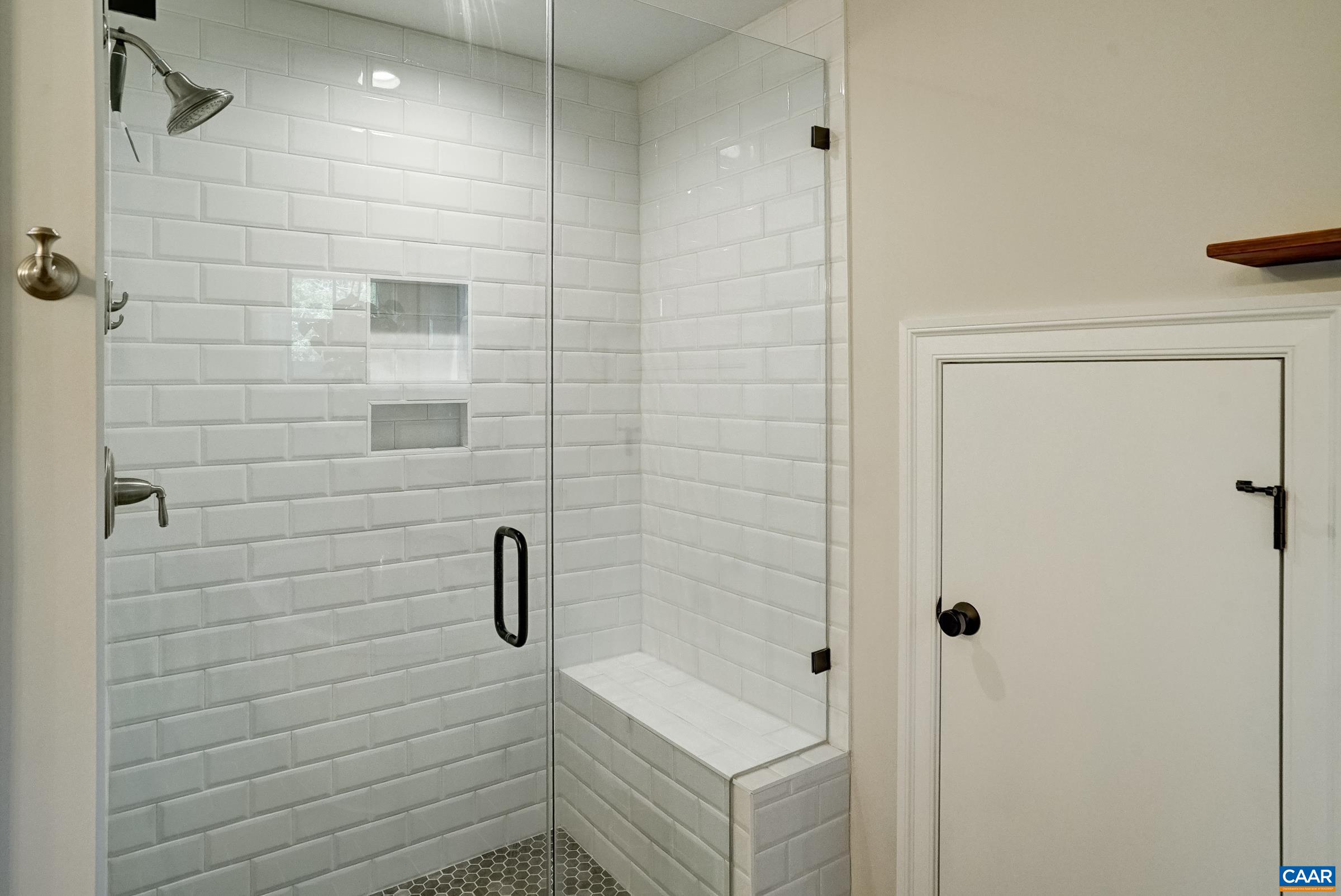 Tile shower with bench - creative space use with under-eave linen closet.