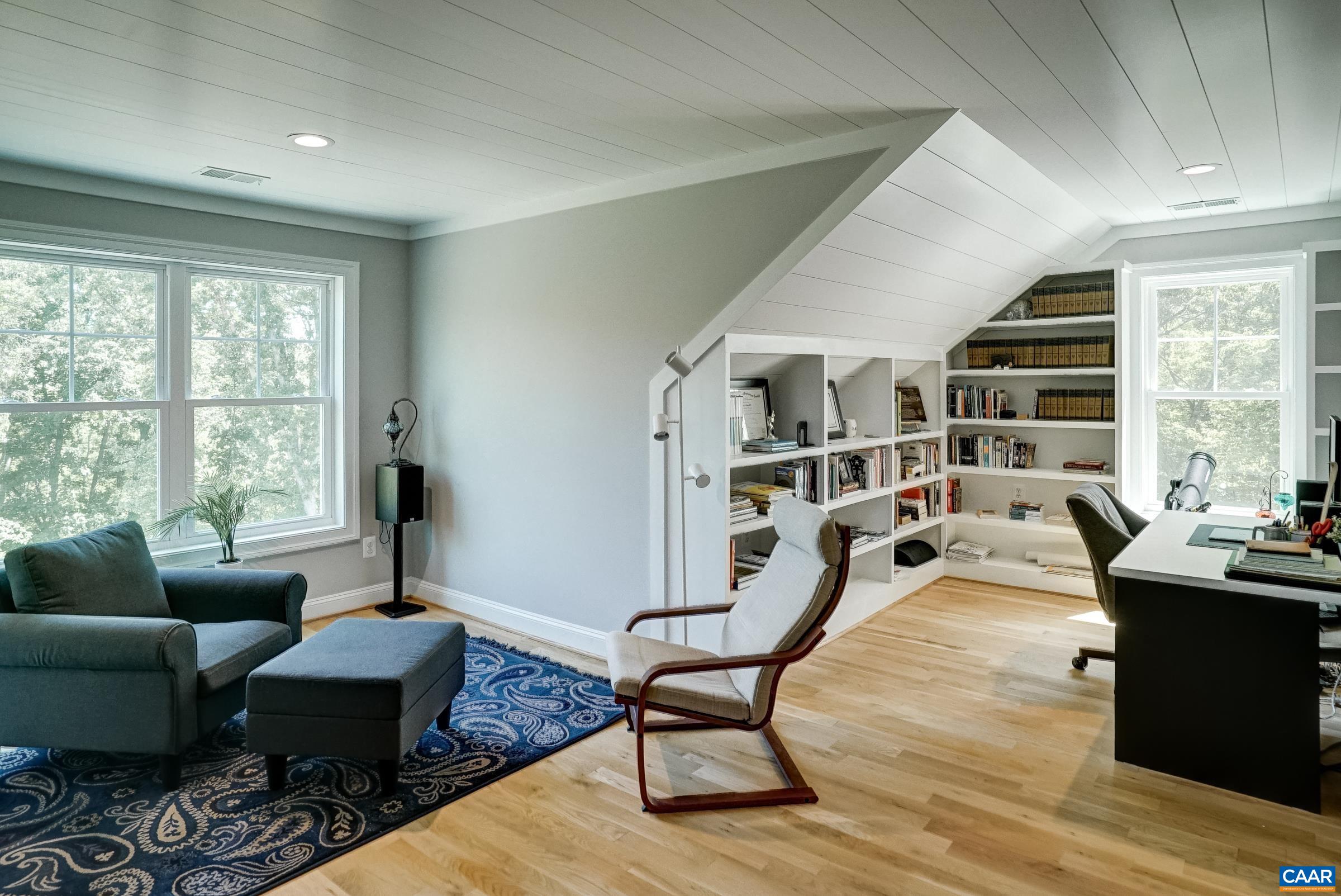 Den/home office on upper level features built-in shelving, wet bar and sitting area.