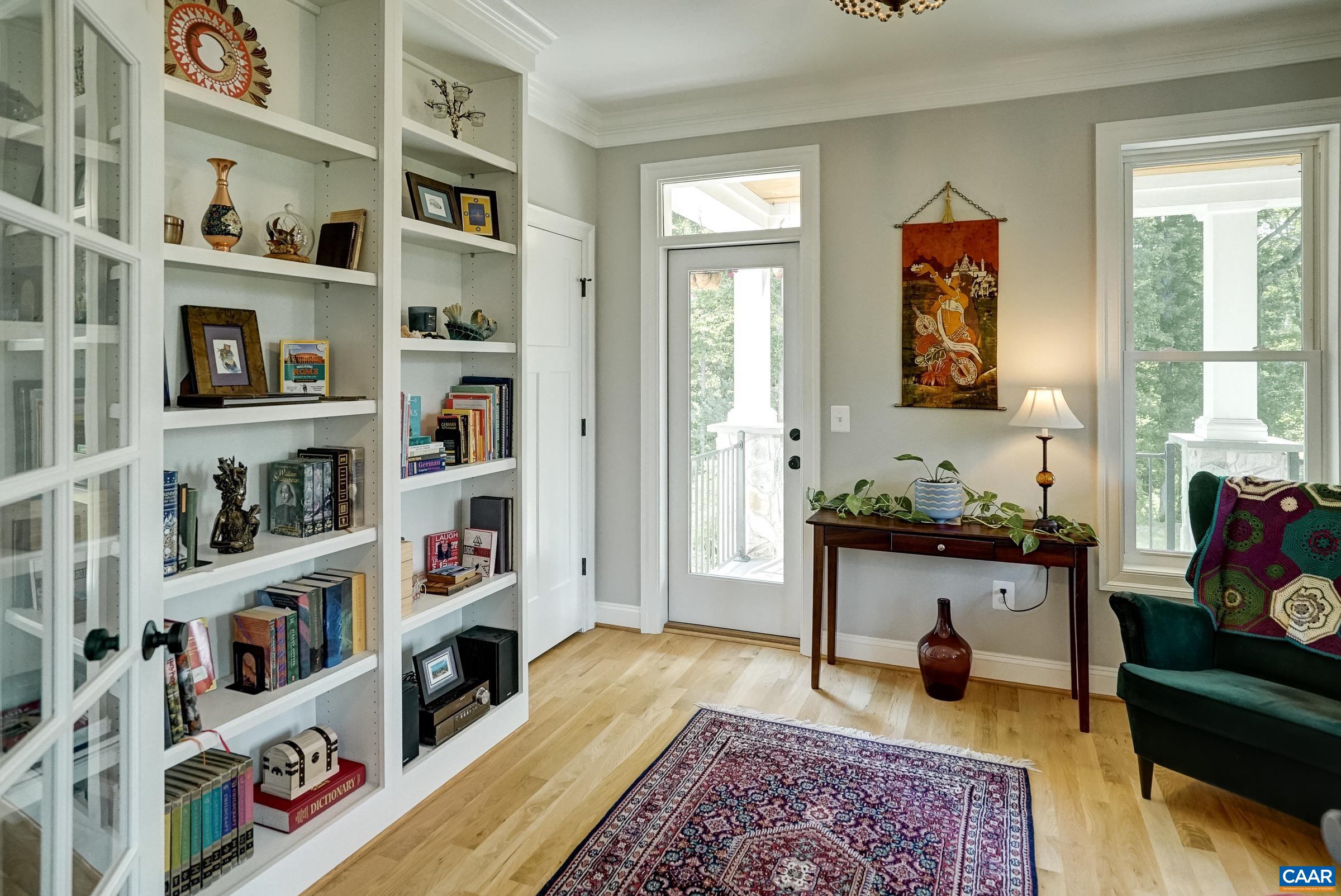Home office/sitting room to the right of the foyer as you enter features french doors and a wall of built-ins.