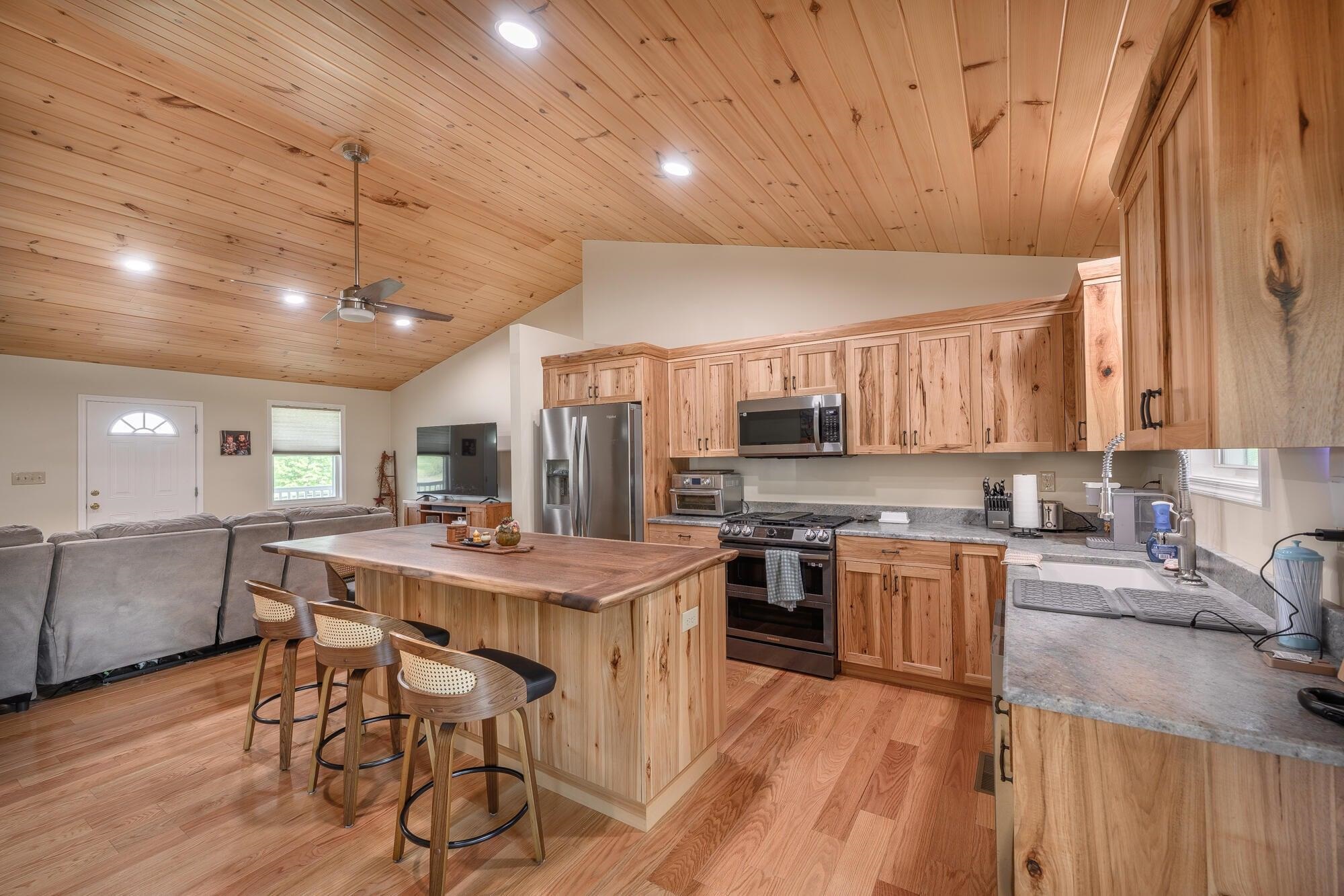 The open floor plan is complemented by a beautiful kitchen featuring custom rustic hickory cabinetry by Walkers Creek Cabinet Work.