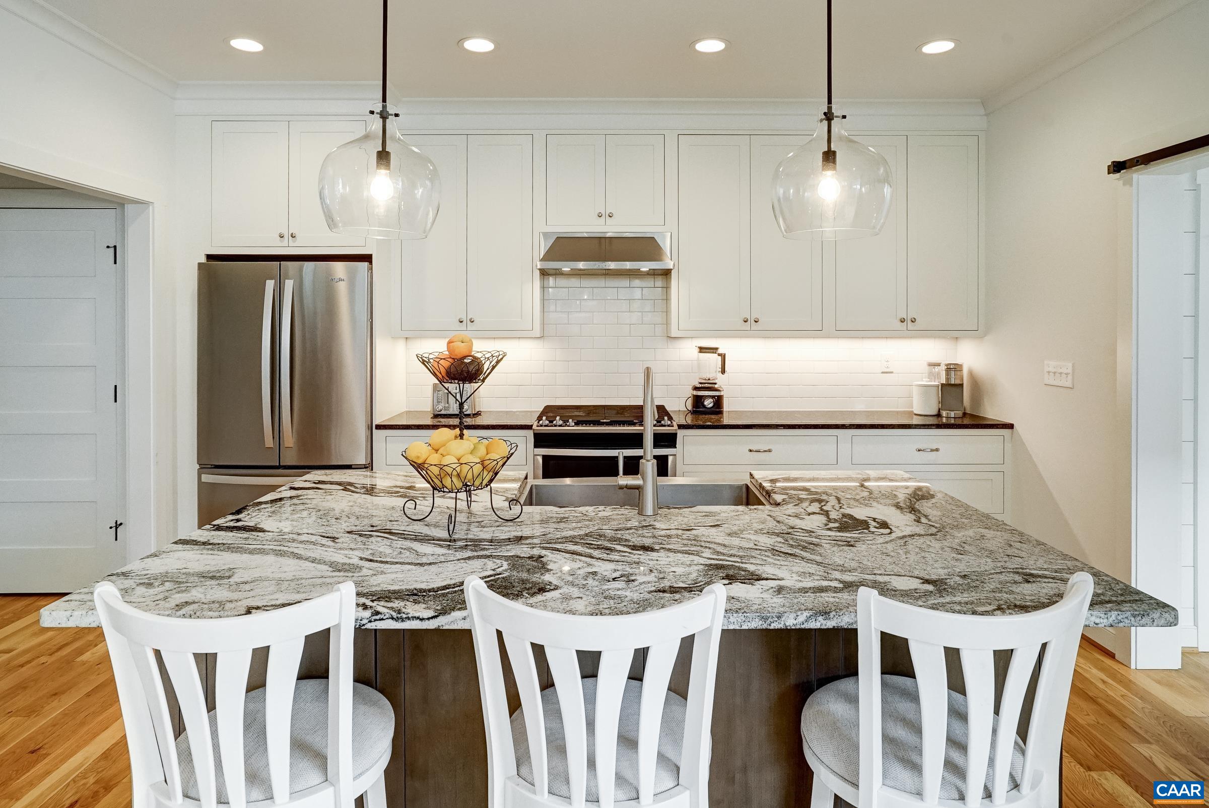 White kitchen cabinets with granite counters and white subway tile backsplash. White kitchen cabinets with granite counters and white subway tile backsplash.