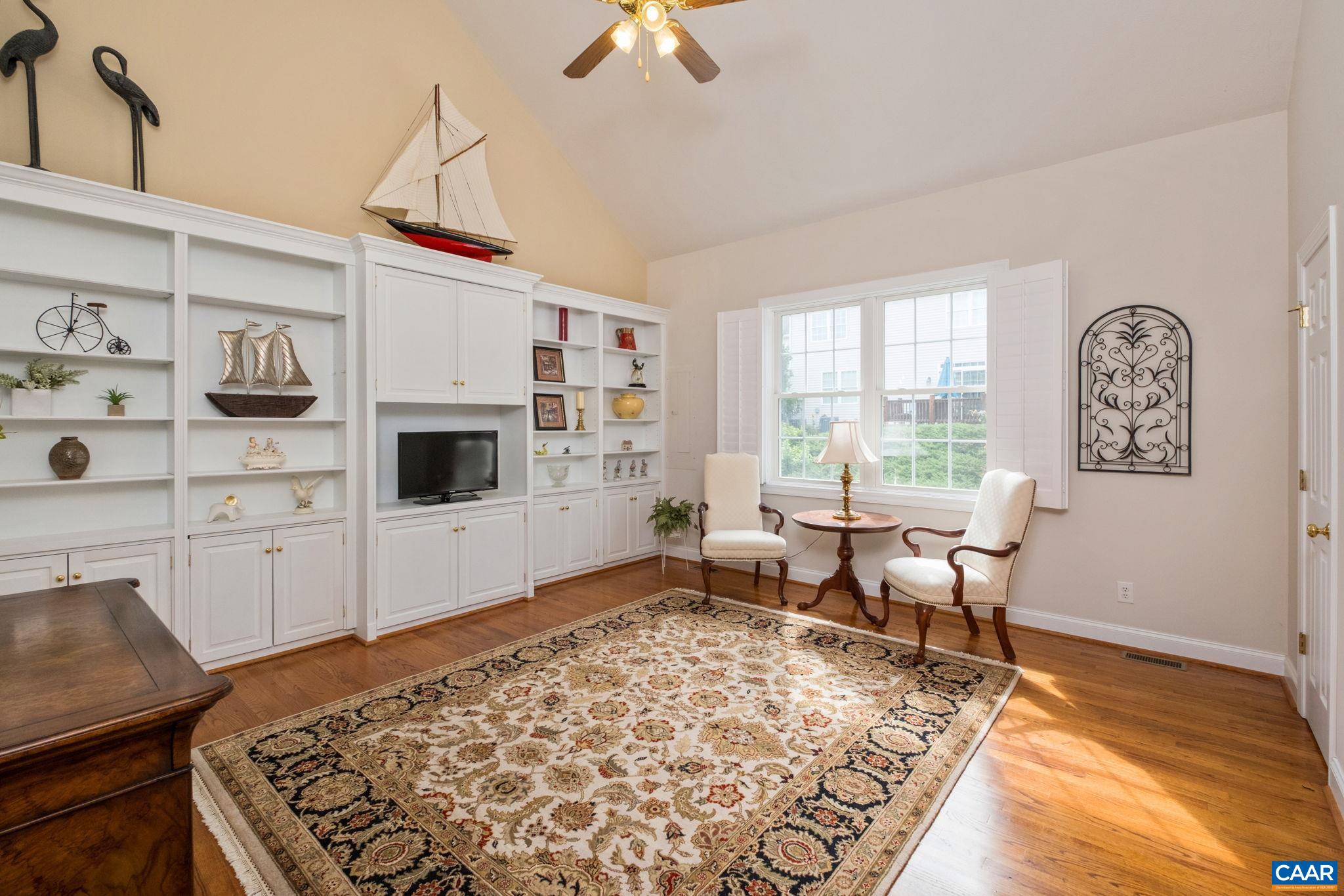 The main level features a primary bedroom suite. The room is large and features built-in bookshelves and custom blinds. It is currently used as a sitting room. The main level features a primary bedroom suite. The room is large and features built-in bookshelves and custom blinds. It is currently used as a sitting room.