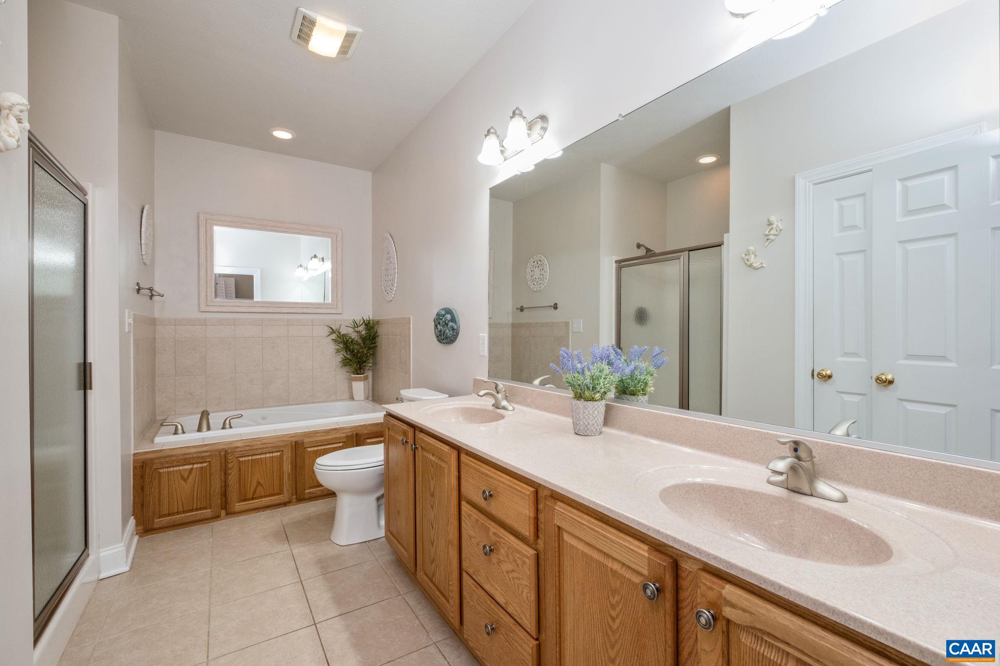 The primary bathroom on the main level features a walk-in closet, dual vanities, shower, and a jetted tub. The primary bathroom on the main level features a walk-in closet, dual vanities, shower, and a jetted tub.