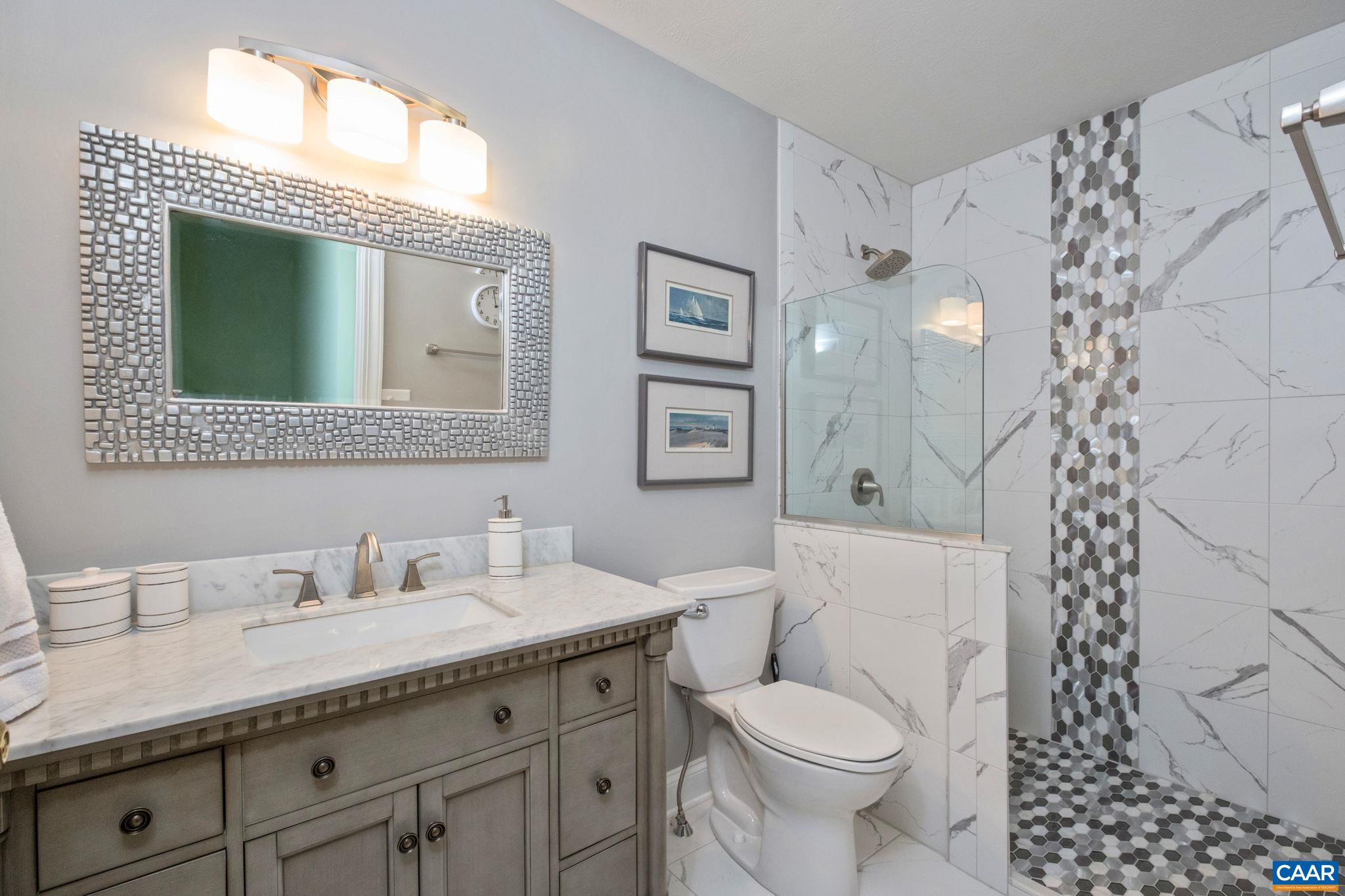 The full bathroom on the second level features a tiled shower. The full bathroom on the second level features a tiled shower.