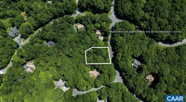 Charming mountain homesite featuring a level building site, privacy along the rear, and dramatic natural rock formations bordering the right side of the property.