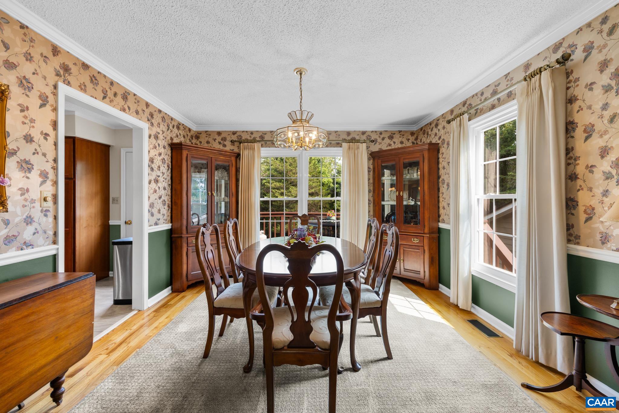 Host unforgettable dinners in this formal dining room! Highlights include gleaming hardwood floors, classic chair rail molding, rich wood furnishings, and an elegant chandelier. Abundant natural light creates a bright, inviting space for hosting!