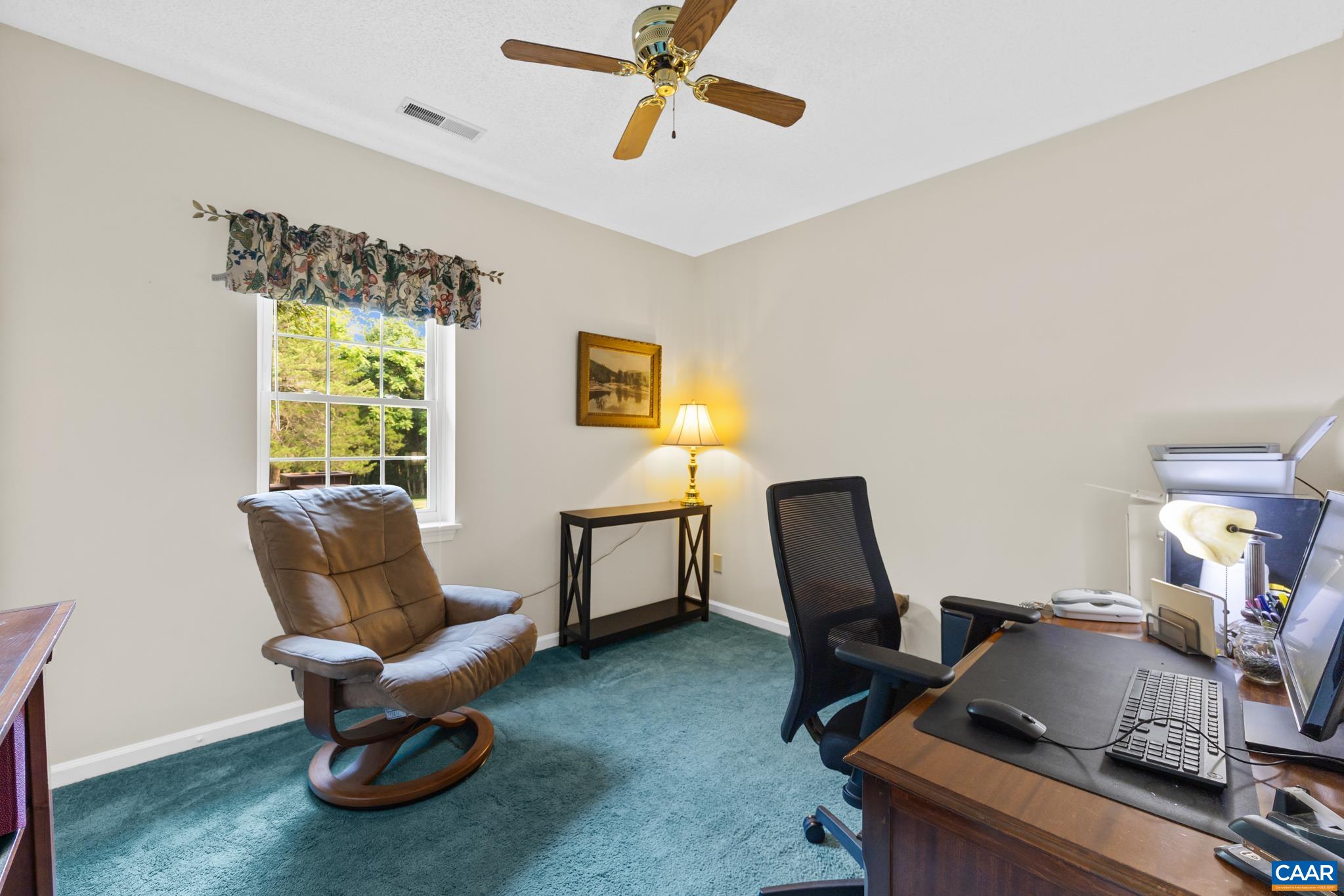 Work efficiently from home in this versatile dedicated office space! Highlights include neutral walls, soft carpet, a wood ceiling fan, and a bright window allowing abundant natural light. Ideal as a home office, study, or cozy reading den!