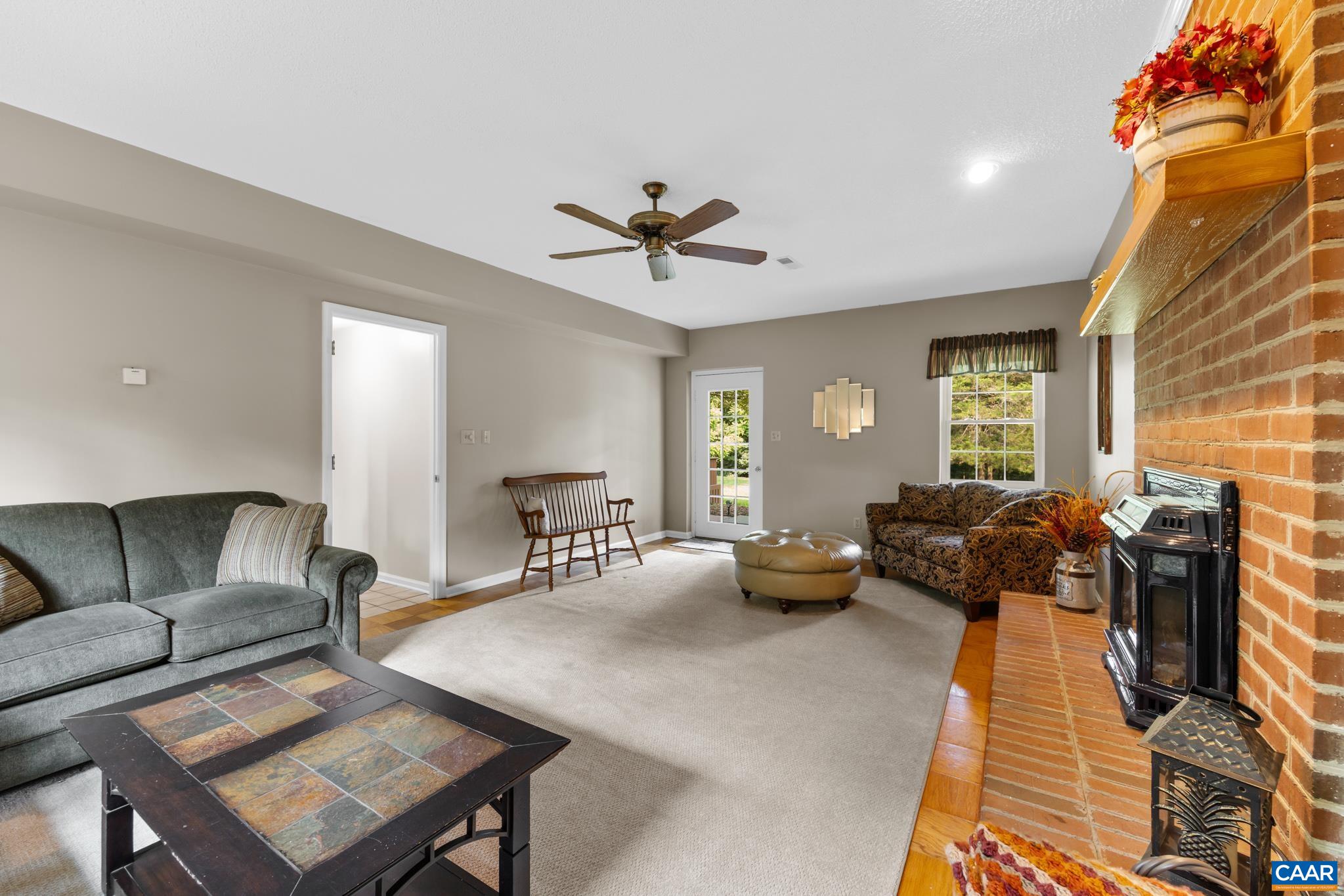 Unwind in this warm, inviting living space! Featuring a magnificent brick fireplace, stylish ceiling fan, and ample room to relax or entertain. Sunlight streams through the back window, making this spacious retreat truly feel like home!