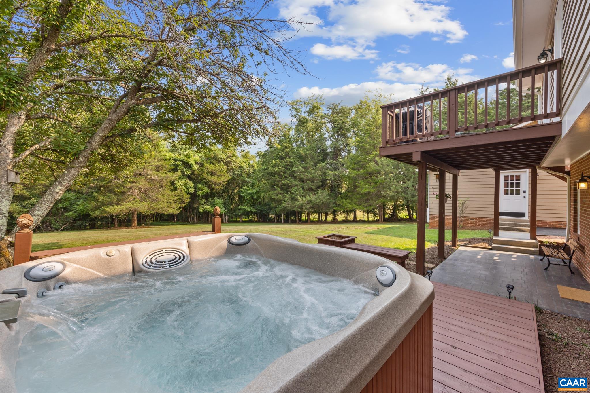 Relax and unwind in your private outdoor oasis! Features a bubbling hot tub, covered stamped concrete patio, upper deck, and a sprawling grassy yard surrounded by mature trees. The ultimate backyard setting for relaxation and entertaining!