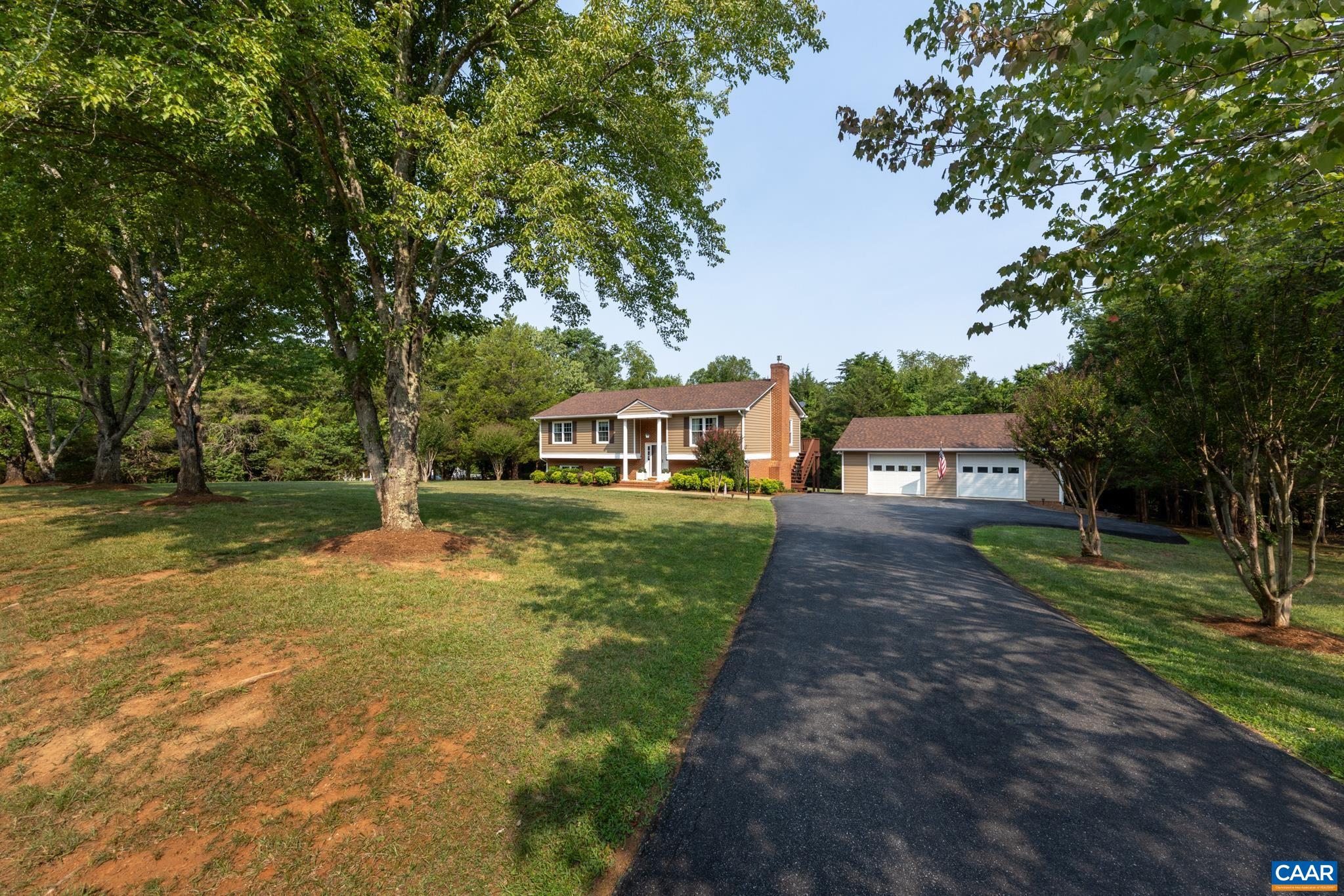 Welcome home to classic curb appeal! Features a long, freshly paved asphalt driveway leading past manicured lawn and mature shade trees to a lovely brick-accented home and a spacious detached multi-car garage/workshop!