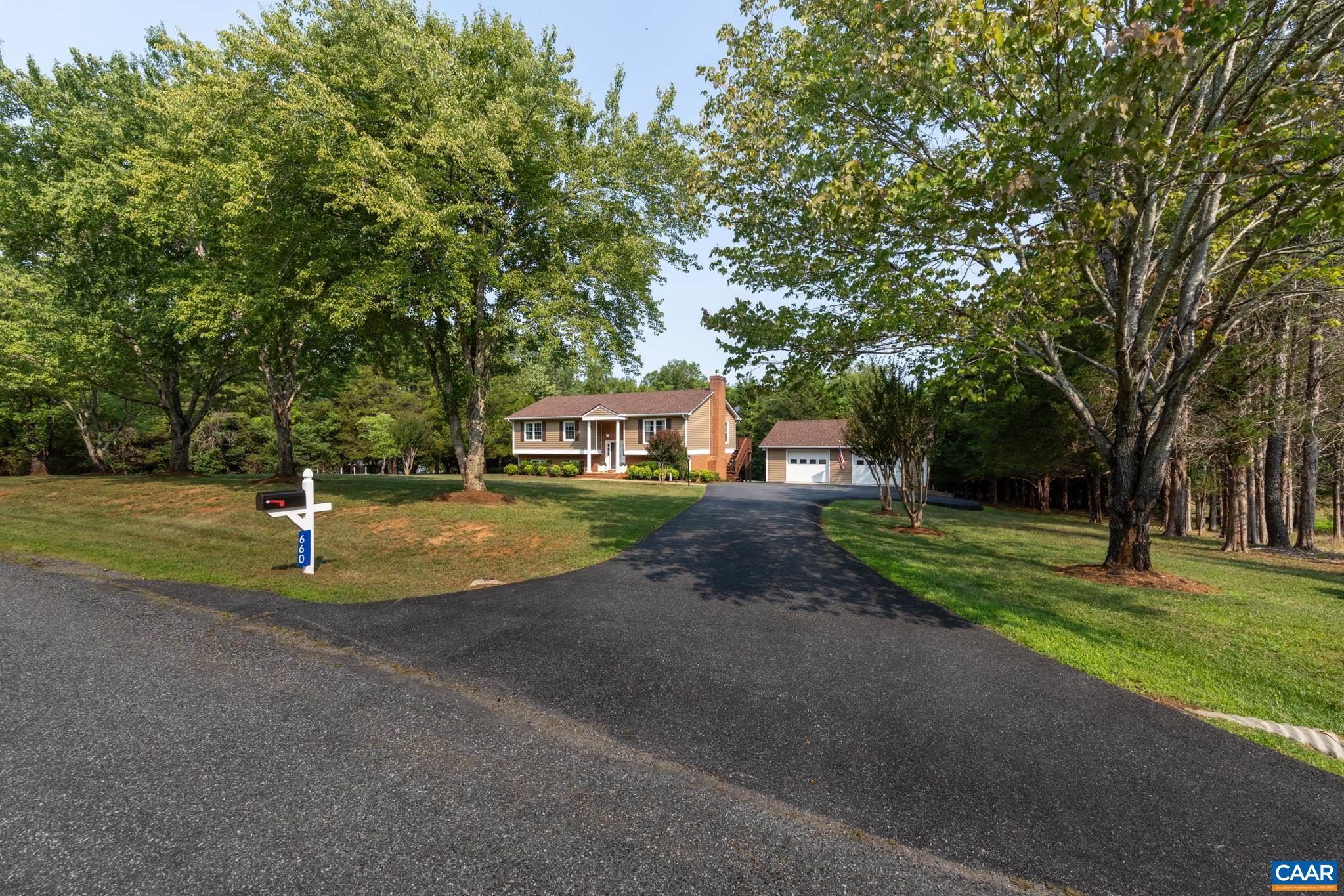 Welcome home to private country charm! Features a sweeping paved asphalt driveway leading past a lush front lawn, and mature shade trees toward a lovely brick-accented home and detached garage/workshop!