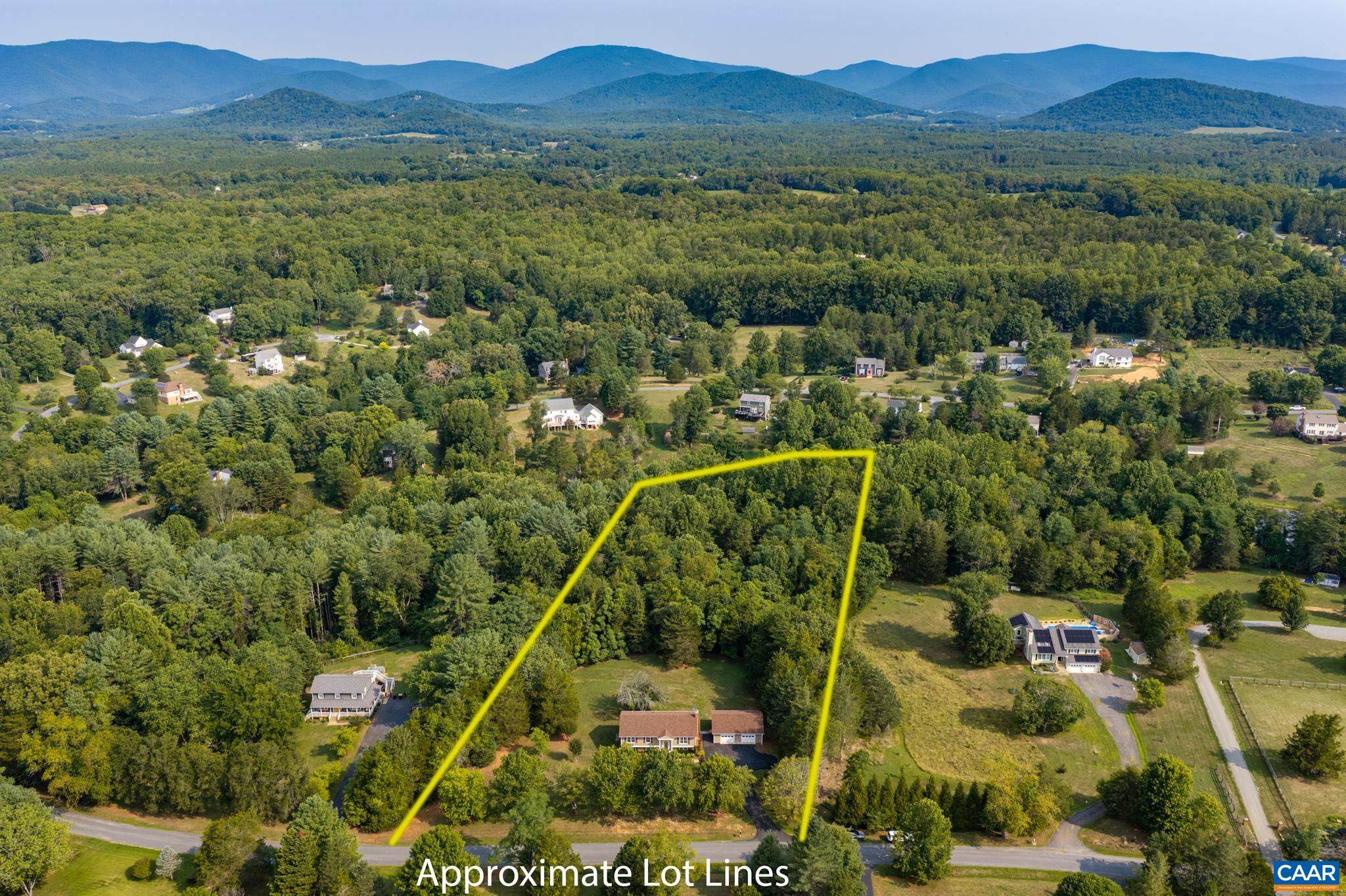 Expansive aerial view displaying approximate lot lines on this prime countryside property! Nestled among lush, mature trees with scenic mountain vistas on the horizon, offering exceptional privacy, clear boundaries, and endless potential!