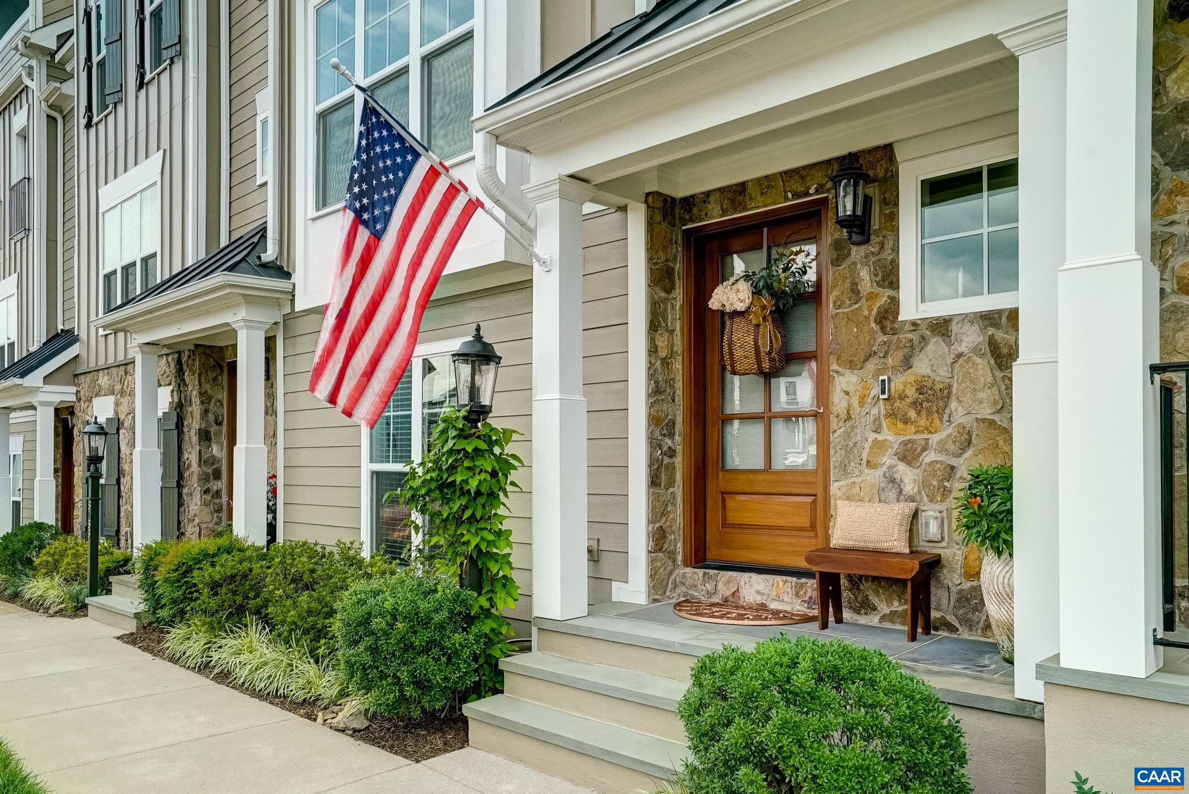 Welcoming front porch with bluestone floor and hardwood door.