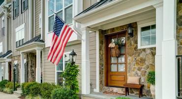 Welcoming front porch with bluestone floor and hardwood door.