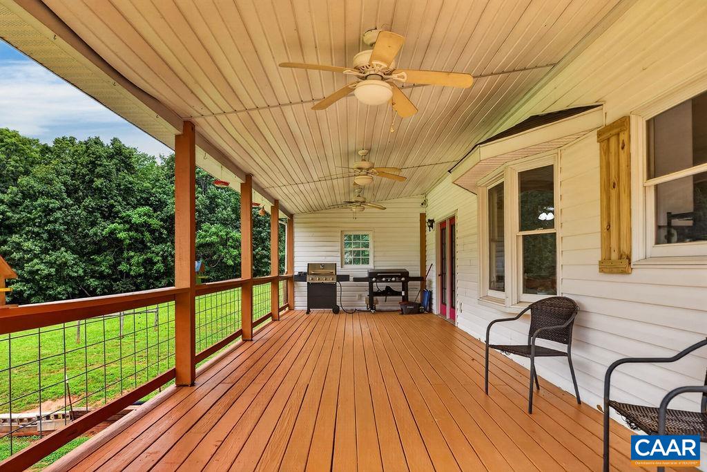 An expansive deck wraps around two sides of the home, with approximately half of it covered for comfortable outdoor living in any weather.