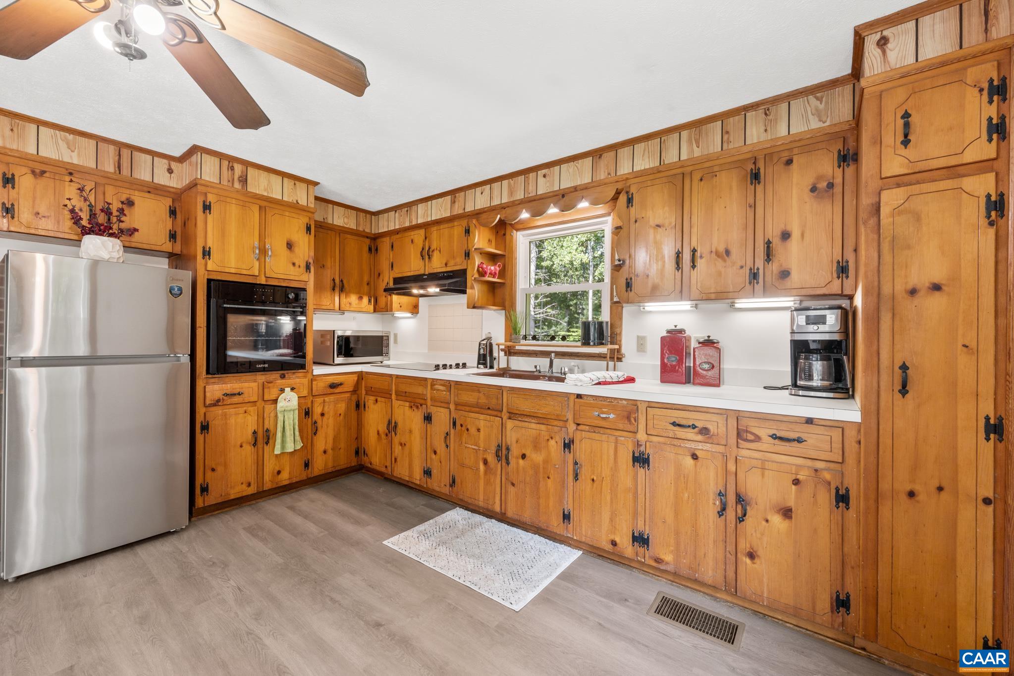The original wood cabinetry brings vintage character and classic charm, while newer luxury vinyl flooring adds a fresh and practical touch.