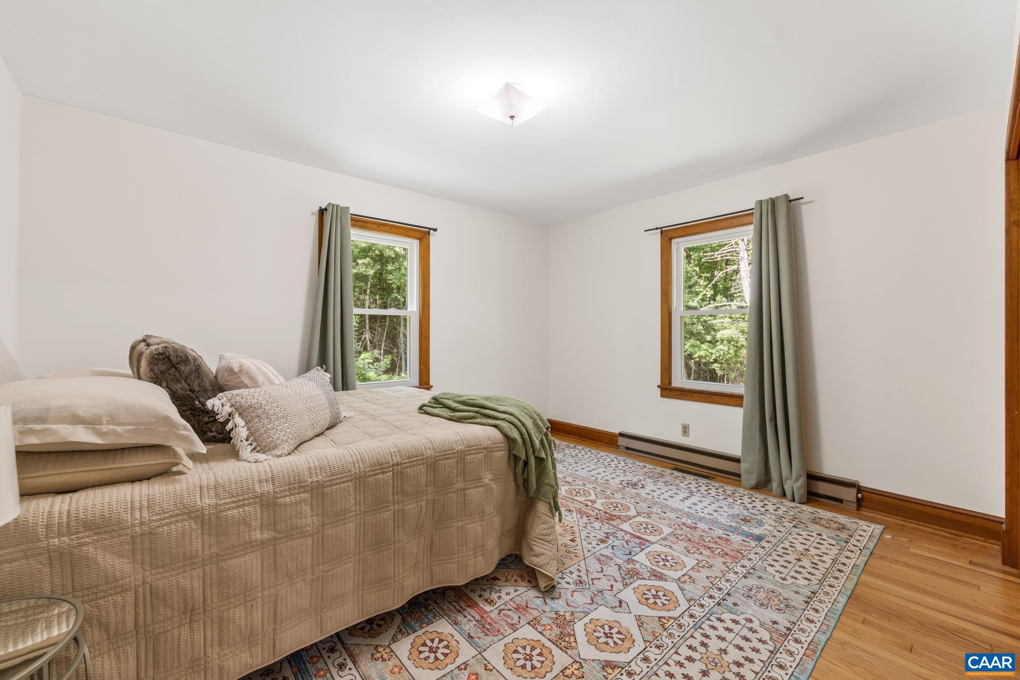 Spacious 1st floor bedroom featuring hardwood floors, room for a king-size bed, ample closet space and abundant natural light from the 2 well placed windows.