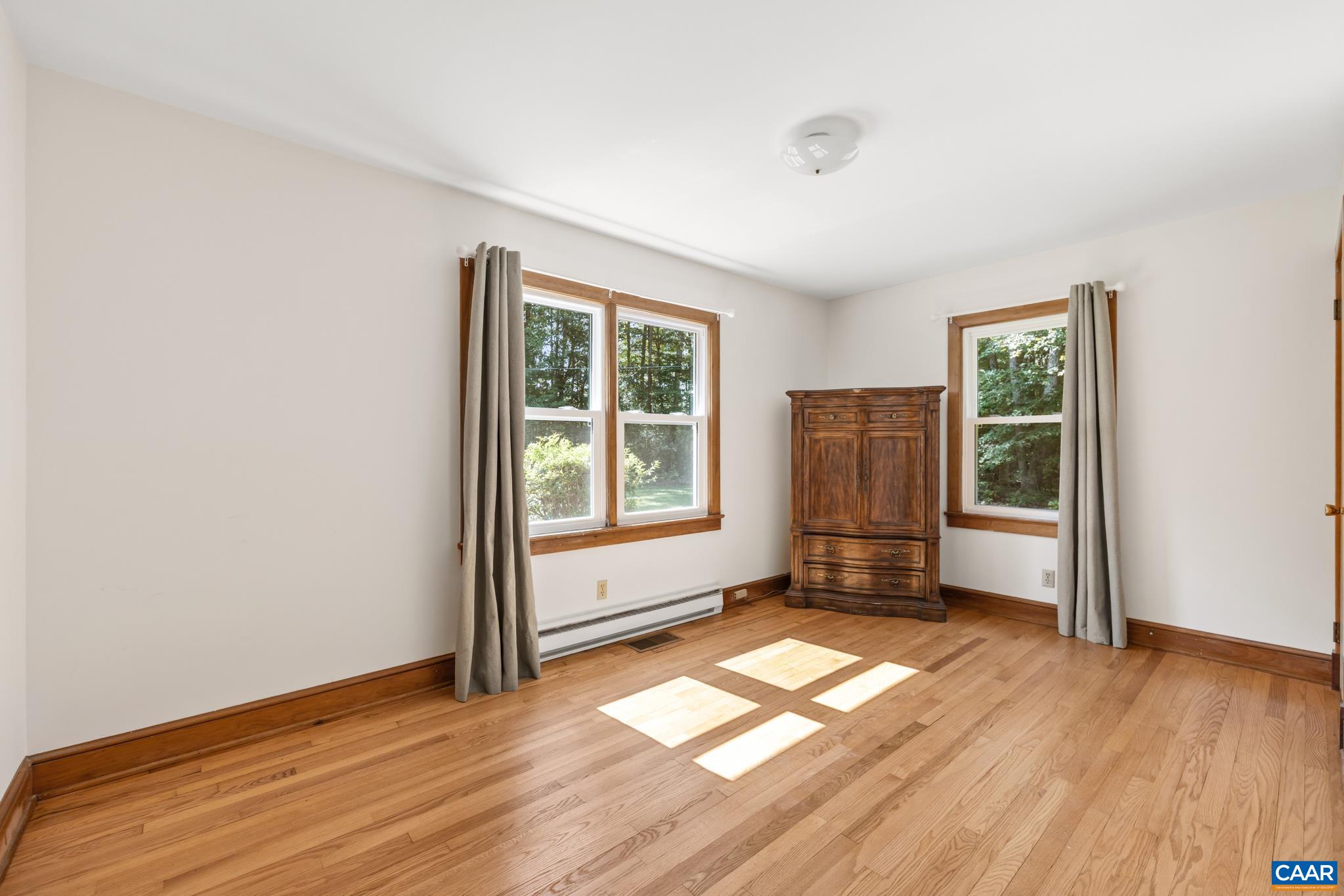 This bedroom is located at the front corner of the home featuring hardwood floors, overhead lighting and windows overlooking the front and side yard with great sunlight.