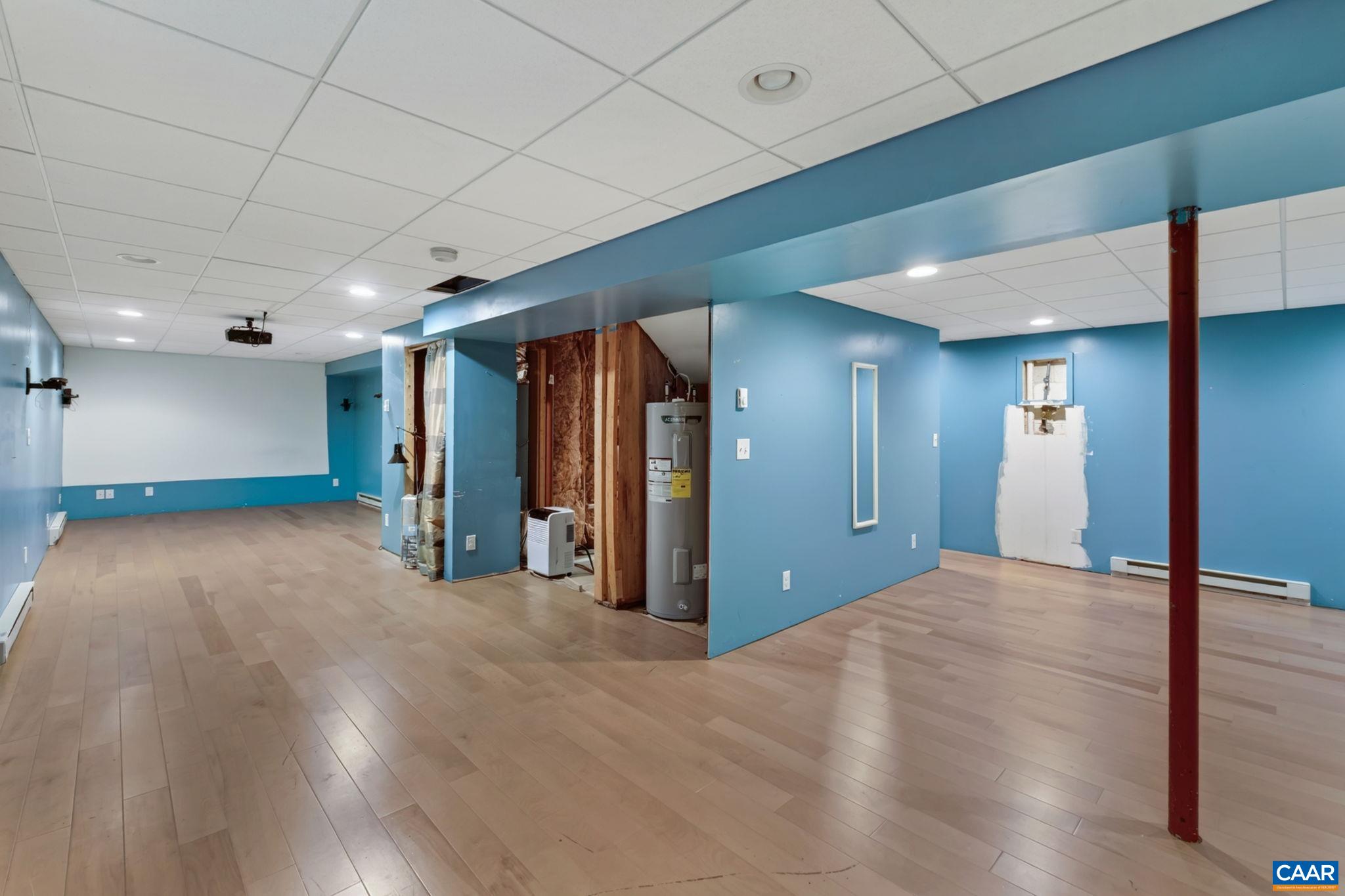 Around the corner is this area that is ideal for a home movie theater space! Plus, the unfinished area is ready to go with rough-in plumbing for a future bathroom!