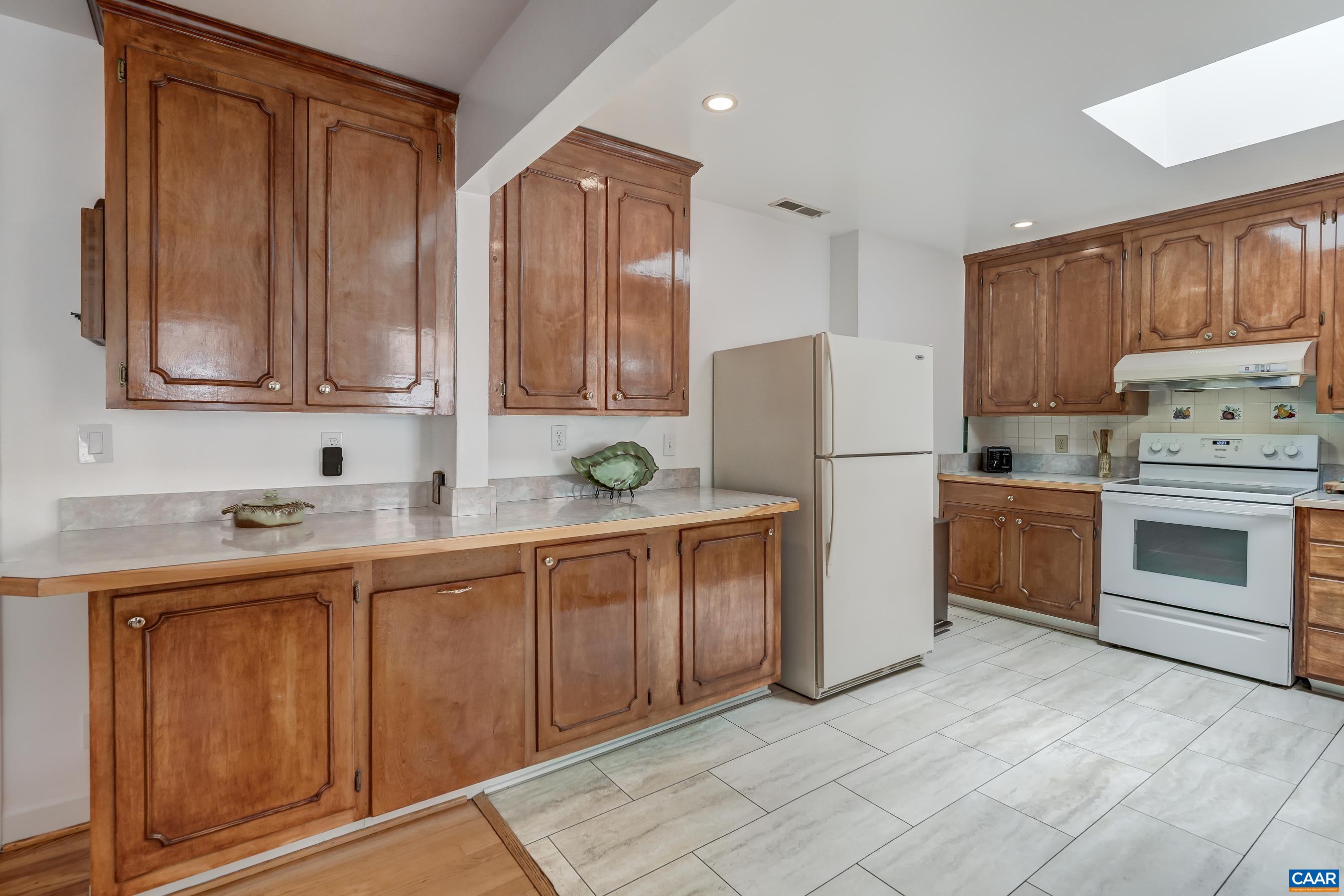 Practical and polished kitchen features oak cabinets and new stainless dishwasher. Practical and polished kitchen features oak cabinets and new stainless dishwasher.