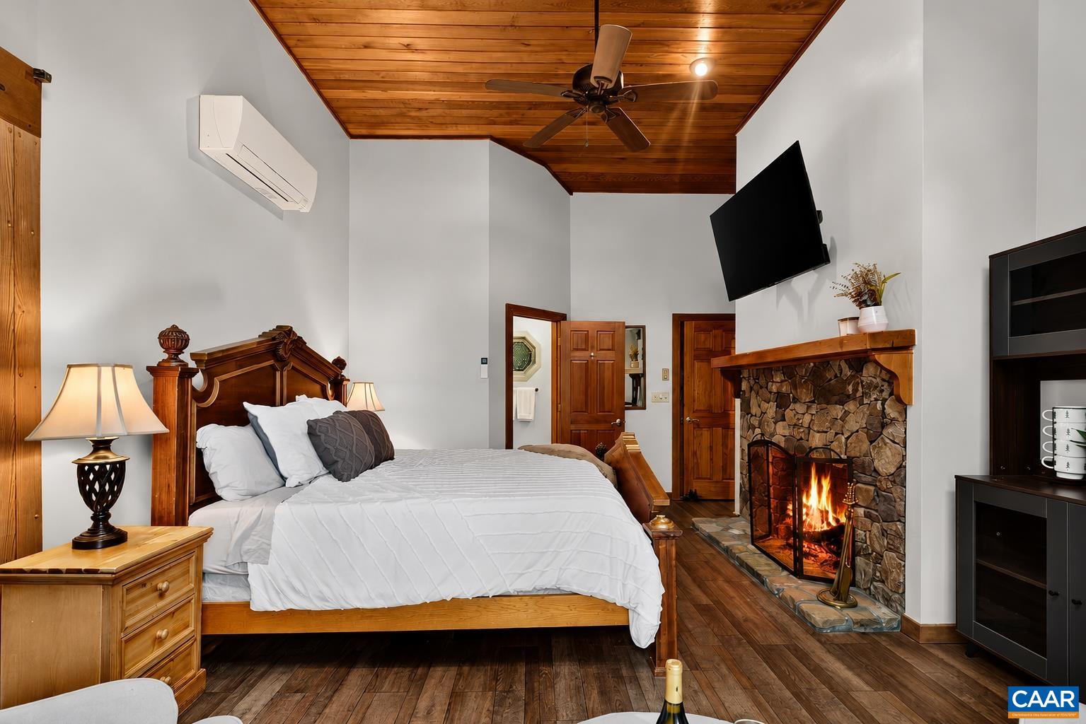 Cathedral ceilings, a beautiful stone wood-burning fireplace, and a walk-in closet make the primary suite a true retreat. Cathedral ceilings, a beautiful stone wood-burning fireplace, and a walk-in closet make the primary suite a true retreat.
