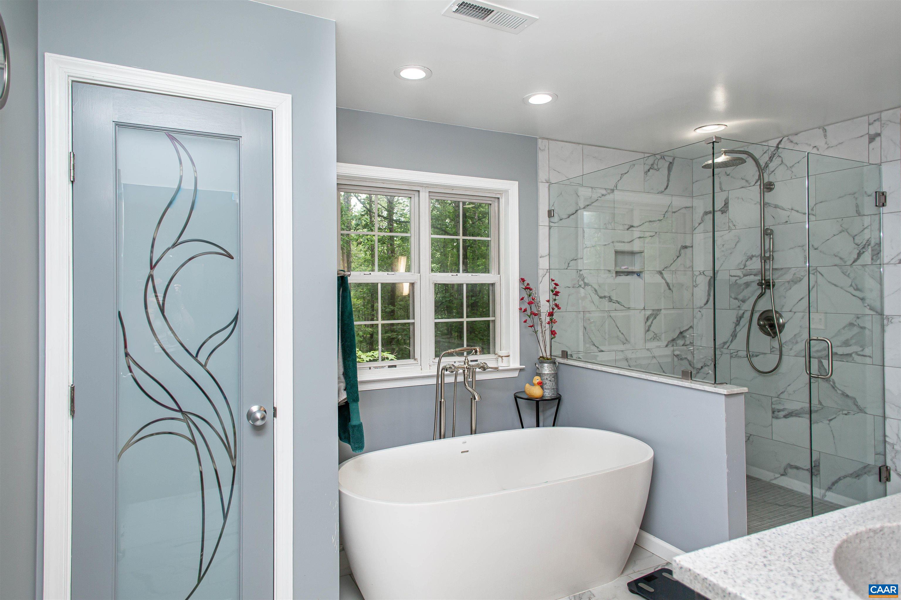 The primary bath includes many custom details including the one-of-a-kind frosted door on the linen closet. The primary bath includes many custom details including the one-of-a-kind frosted door on the linen closet.