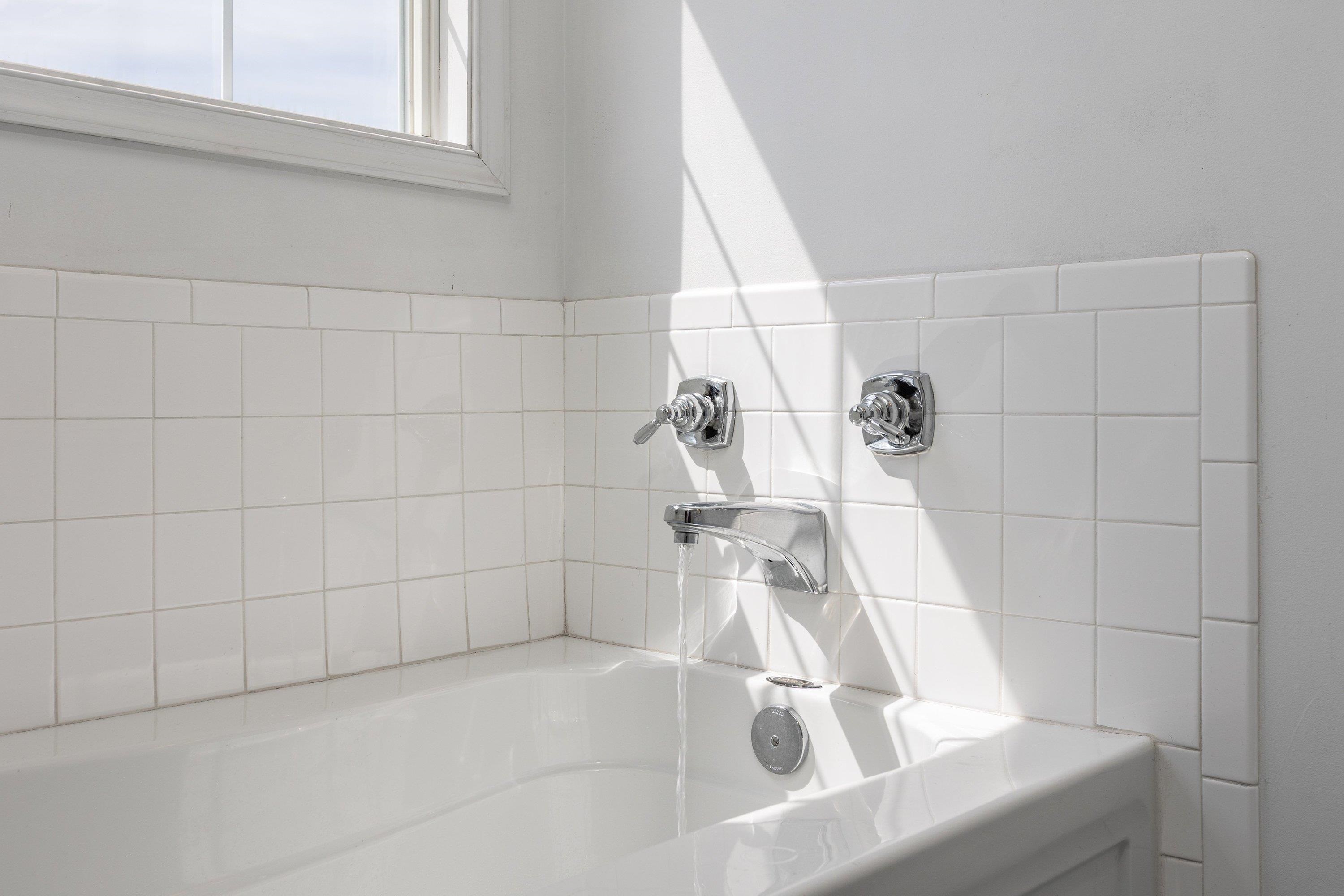 This full bathroom offers dual vanities and a vanity with storage. This space features tile flooring and a bathtub with walk-in shower space. This full bathroom offers dual vanities and a vanity with storage. This space features tile flooring and a bathtub with walk-in shower space.