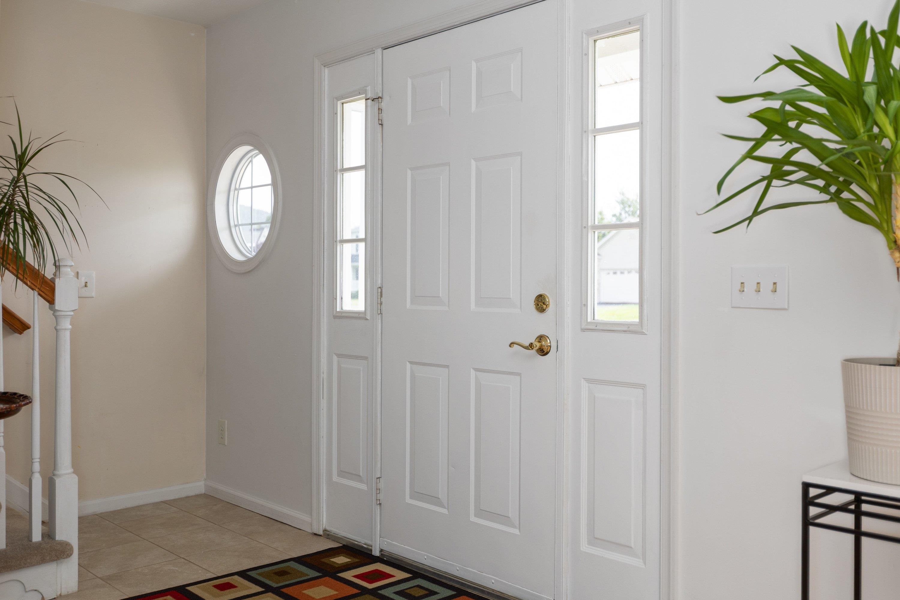 The foyer space features an open concept to the staircase leading to the upper level of the home, a living room space, and hallway leading to the kitchen of the home. The foyer space features an open concept to the staircase leading to the upper level of the home, a living room space, and hallway leading to the kitchen of the home.