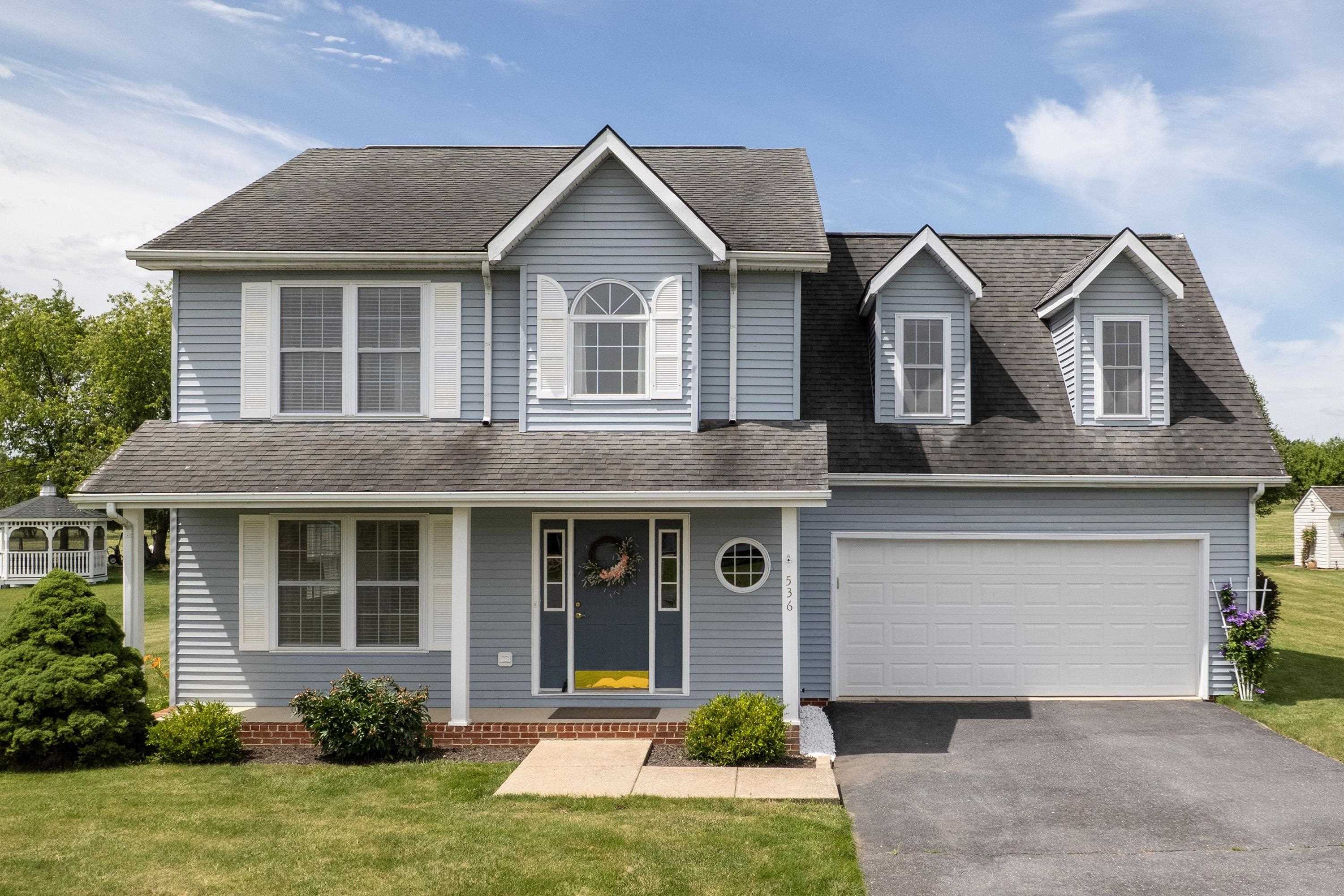The front view of this home located in the Three Leagues subdivision highlights the two-car garage, front porch, large asphalt driveway, and landscaping. The front view of this home located in the Three Leagues subdivision highlights the two-car garage, front porch, large asphalt driveway, and landscaping.
