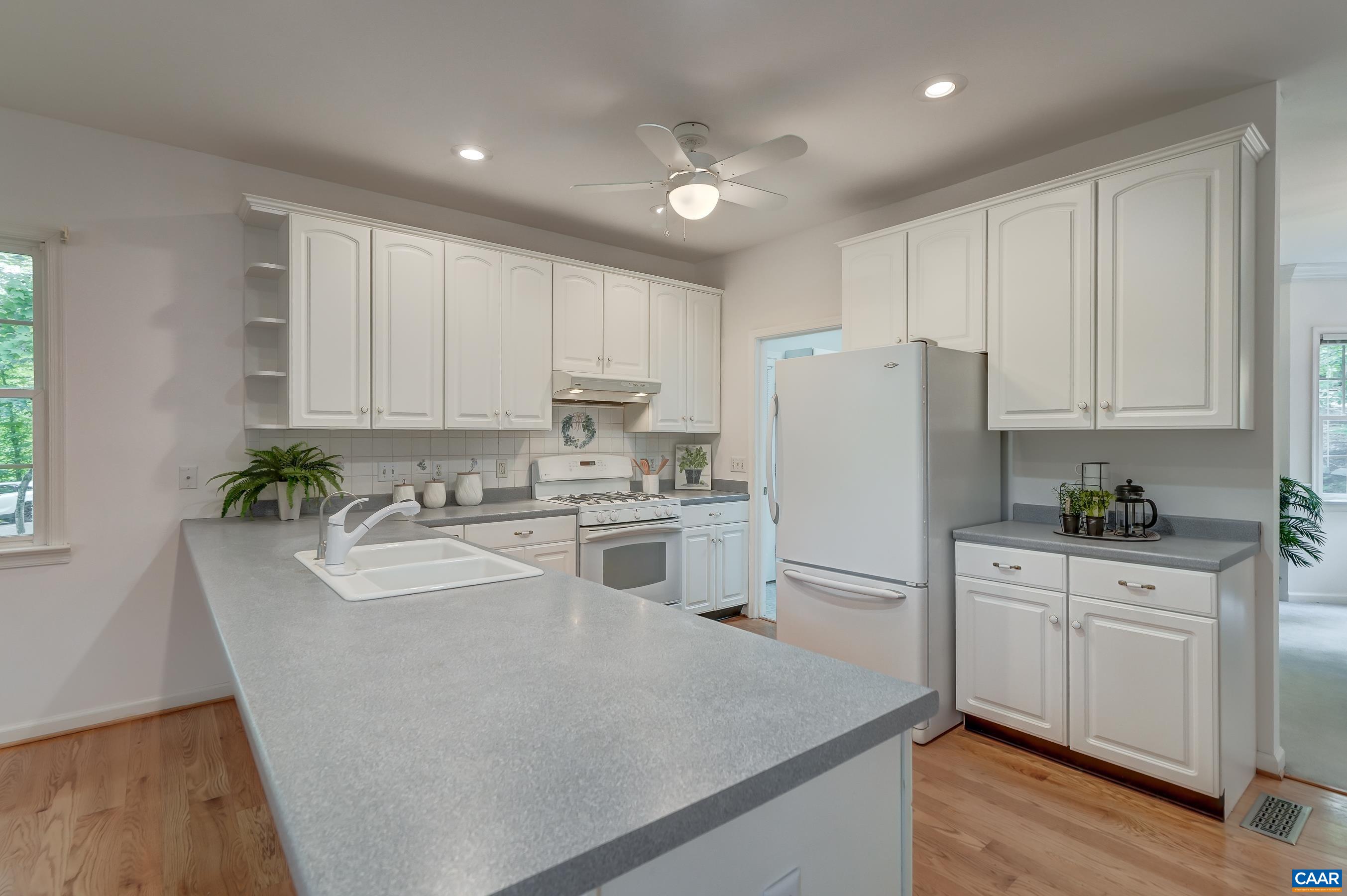 Functional open kitchen with white cabinets Functional open kitchen with white cabinets
