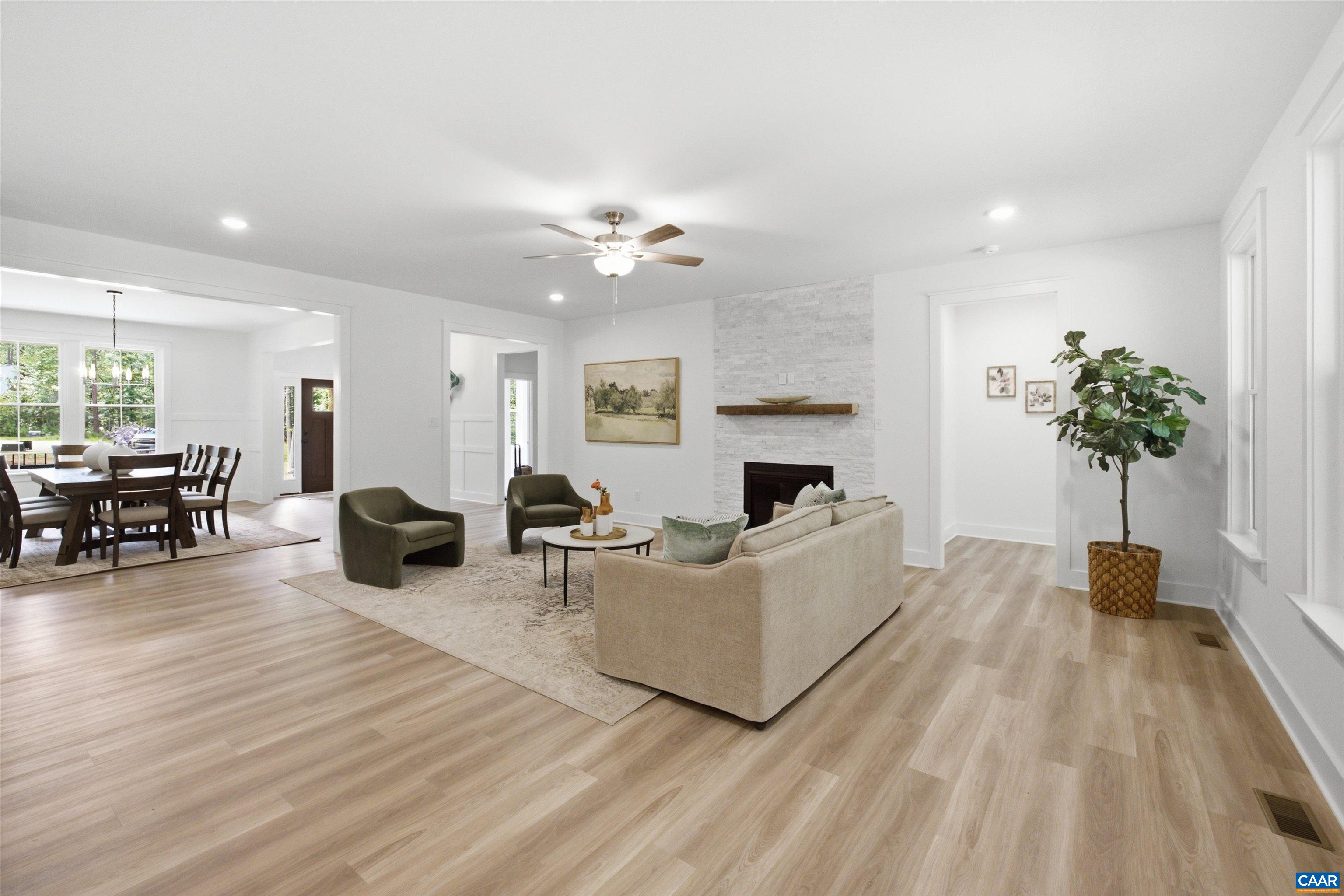 Fireplace in family room. Views to dining room and hall to guest suite. Staged home. Fireplace in family room. Views to dining room and hall to guest suite. Staged home.