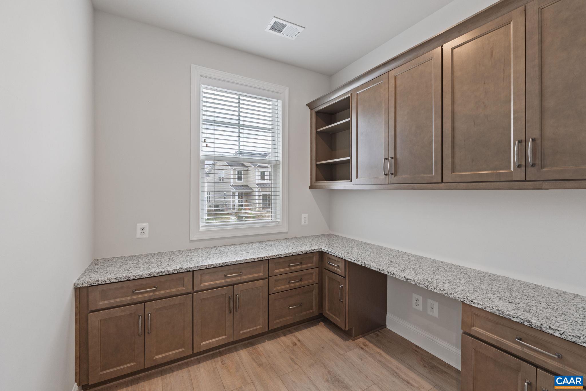 Second level home office with custom cabinetry and granite work space.