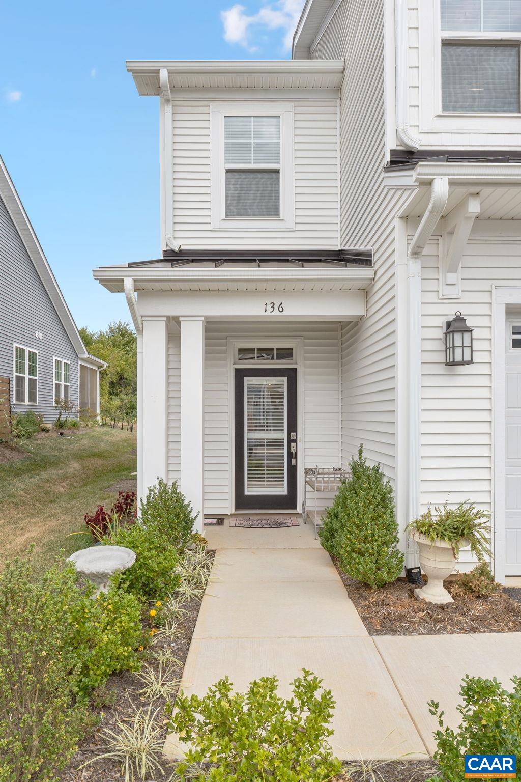 Paved front walkway with garden beds.