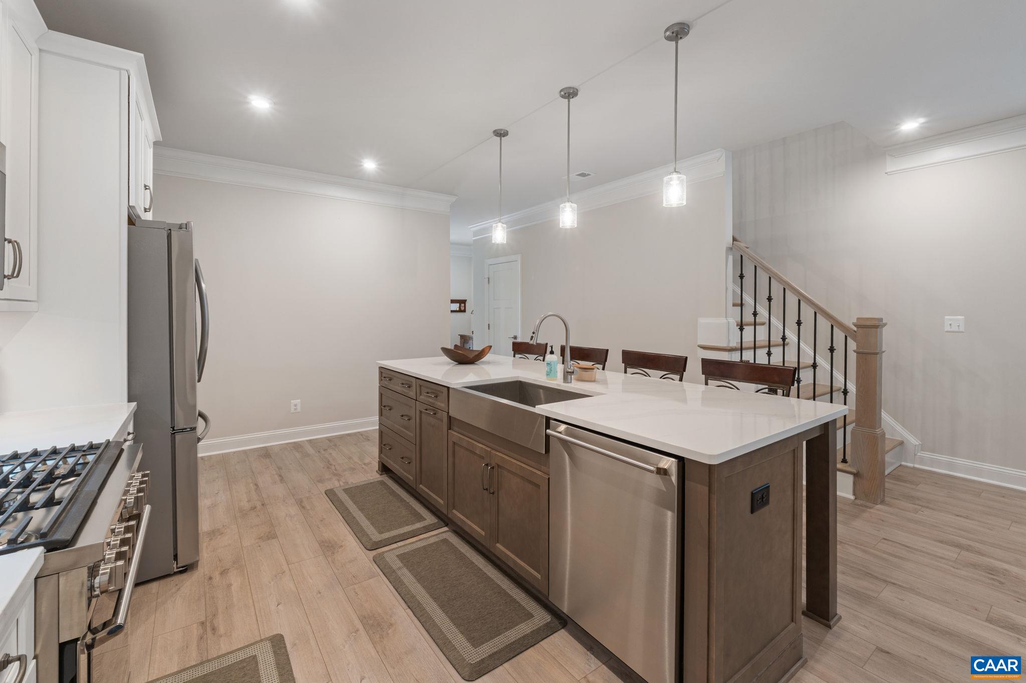 Kitchen island, stairs leading up feature metal spindles.