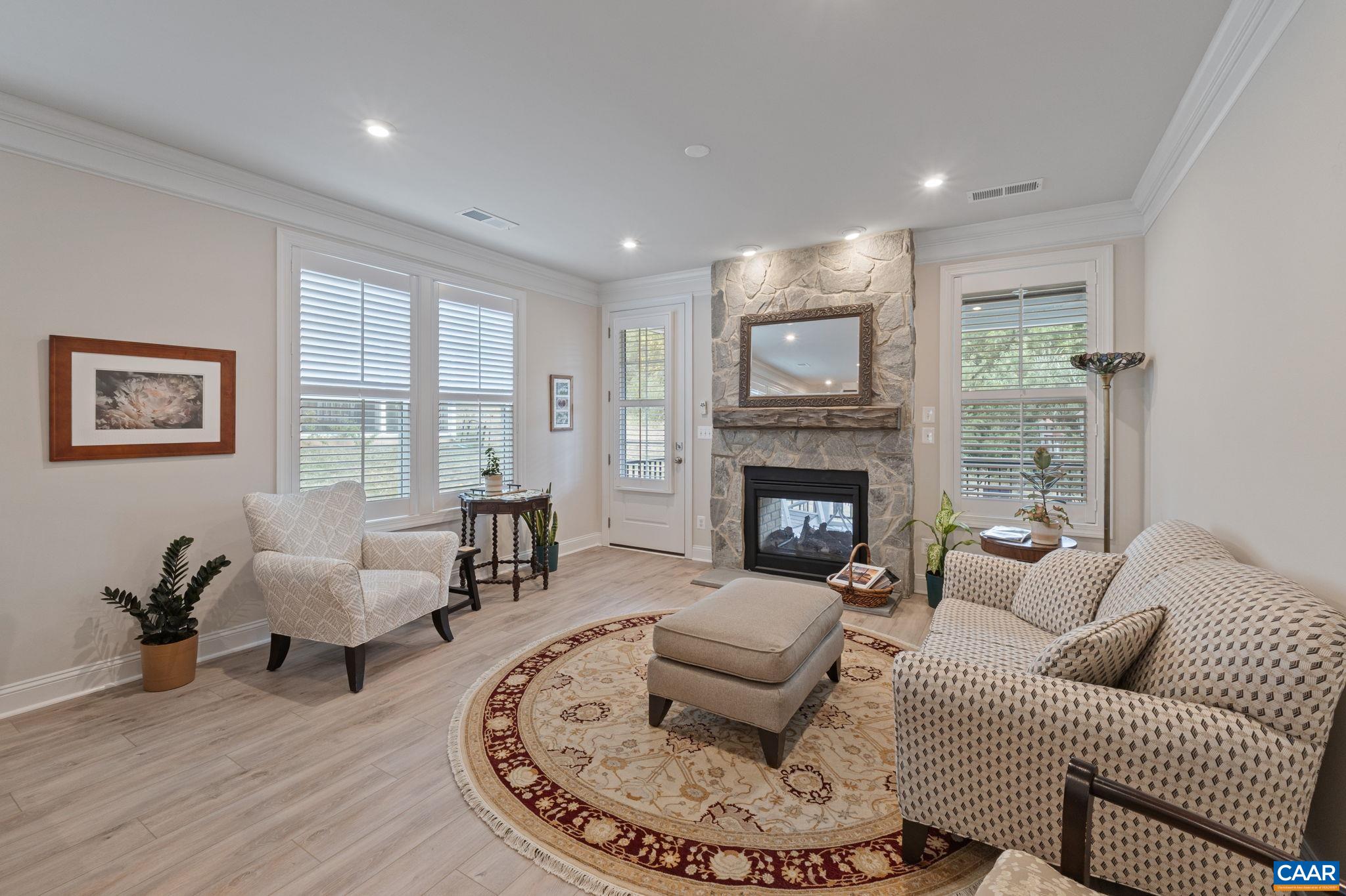 Large and comfortable family room with plantation shutters and see through fireplace.