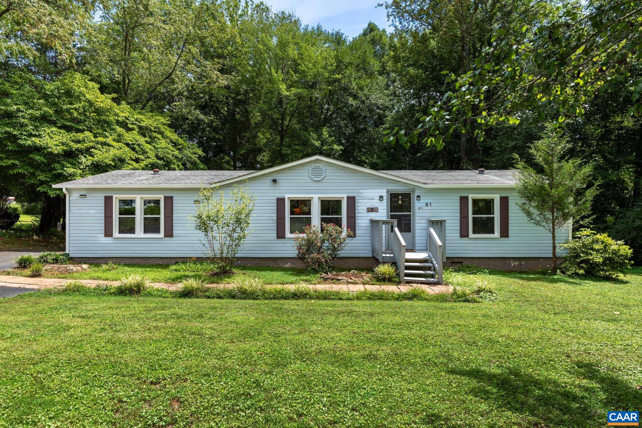 Welcome to your serene retreat! This charming single-story home features classic light siding, crisp dark shutters, and an inviting front porch. Nestled on a spacious, lush lawn surrounded by mature trees, it offers quiet comfort and total privacy.